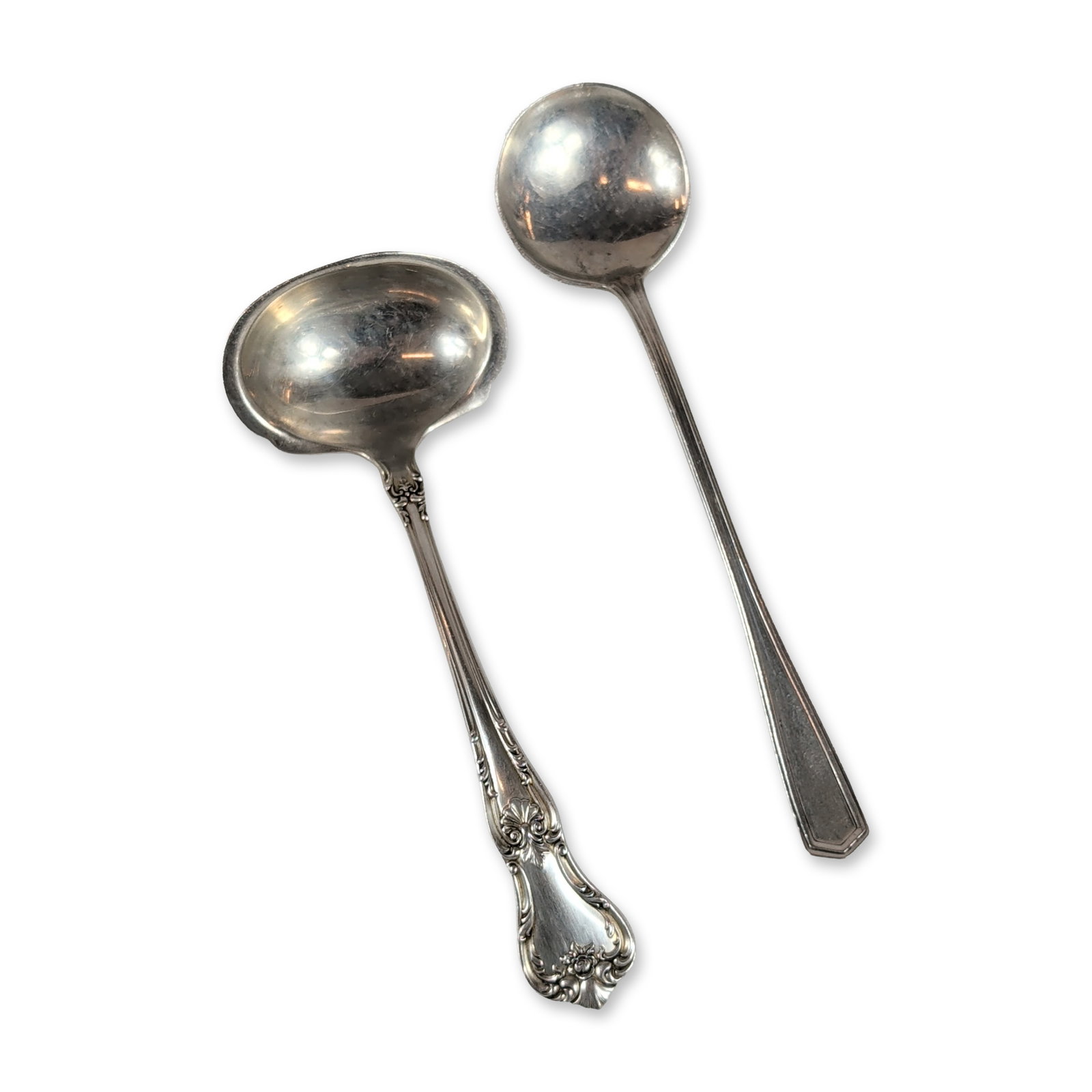 Two American Sterling Silver Ladles: Two American sterling silver ladles comprising a cream ladle and a condiment ladle. The cream ladle is in the Memory Lane pattern by Lunt Silversmiths, featuring a handle with floral and scrollwork de
