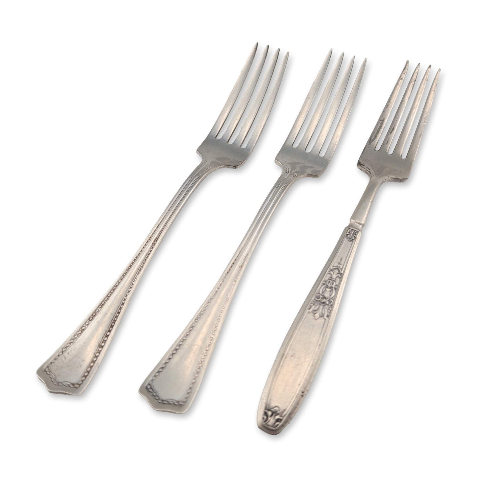 Three 1847 Rogers Bros and William Rogers Silver Plate Forks: The collection includes one fork by 1847 Rogers Bros in the Ambassador pattern, featuring ornate floral and scroll handle motifs, and two forks by William Rogers Mfg. Co. characterized by bracketed