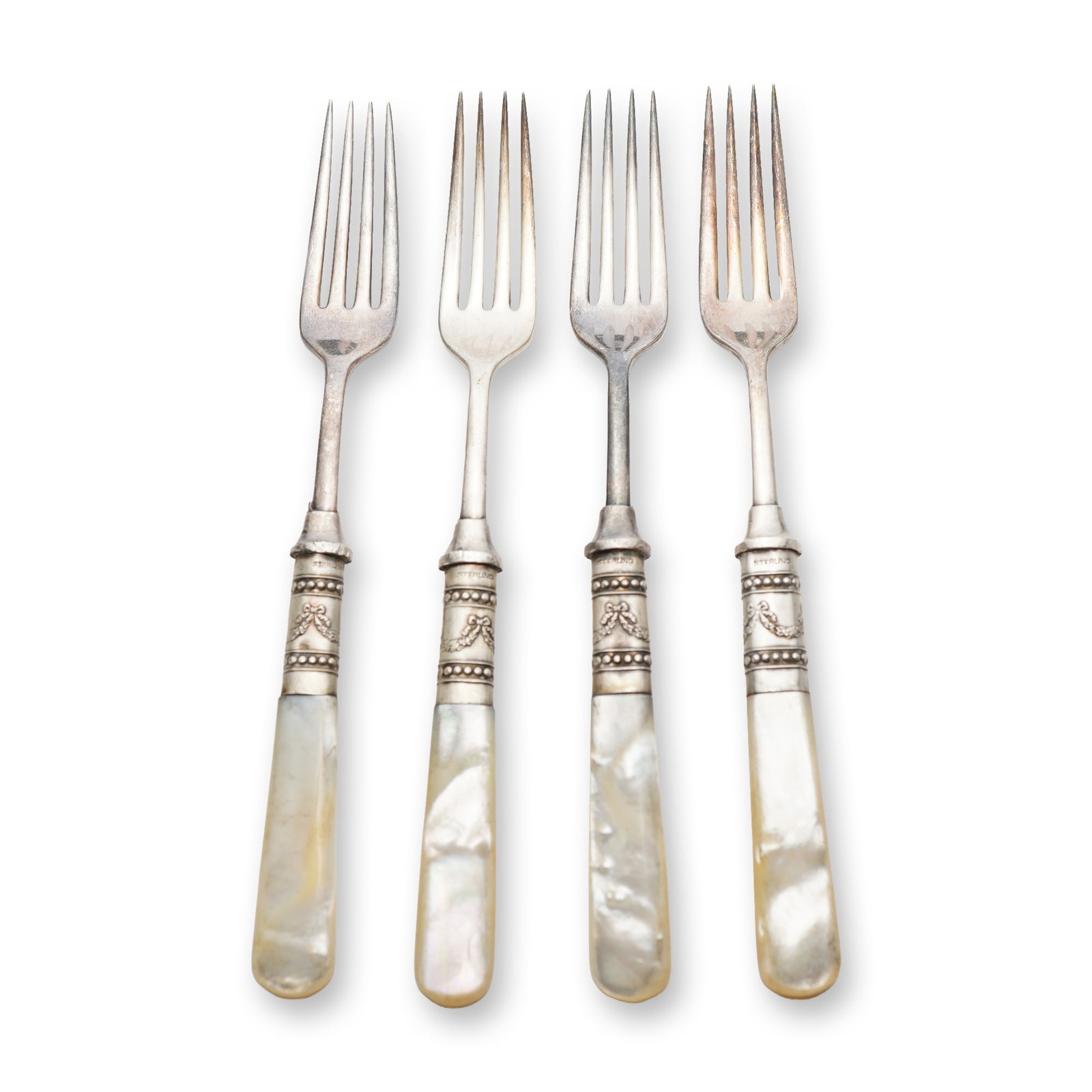Set of Four Sterling Collar Mother of Pearl Forks: American, late 19th or early 20th century. Set of four dessert or fruit forks featuring mother-of-pearl handles and sterling silver collars. Each handle is crafted from carved mother-of-pearl with a