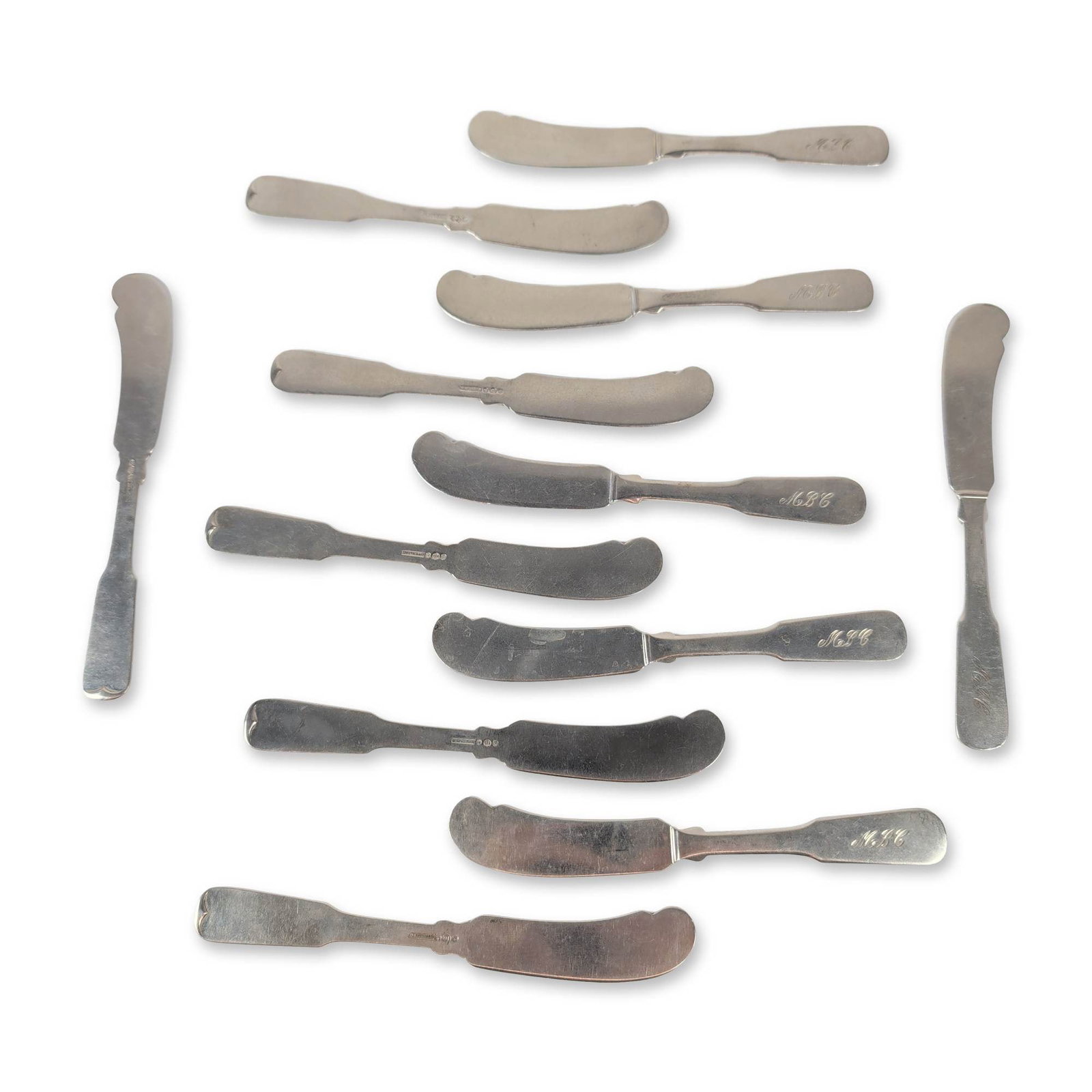 Set of Twelve Watson Co. Sterling Silver Butter Spreaders: Watson Company (Attleboro, Massachusetts) set of twelve butter spreaders in sterling silver, featuring fiddle-style handles with rounded terminals and curved blades. Stamped STERLING with circular hal