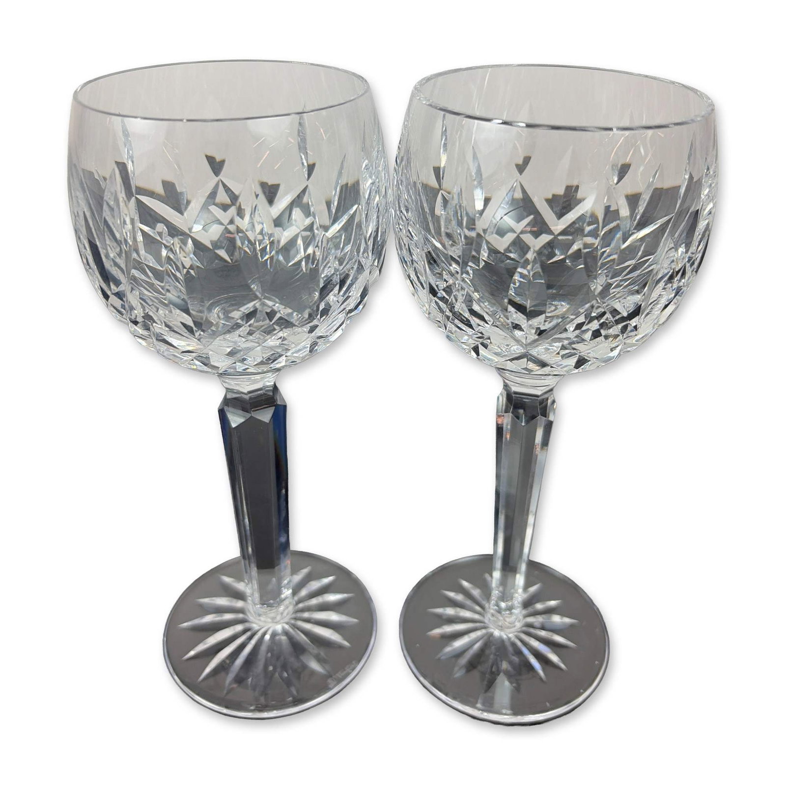 Pair of Waterford Lismore Cut Crystal Balloon Wine Glasses: Waterford. Pair of balloon wine glasses in the Lismore pattern, crafted in cut lead crystal. The bowls feature a lower field of deep crisscross diamond cuts beneath a row of elongated vertical wedge c