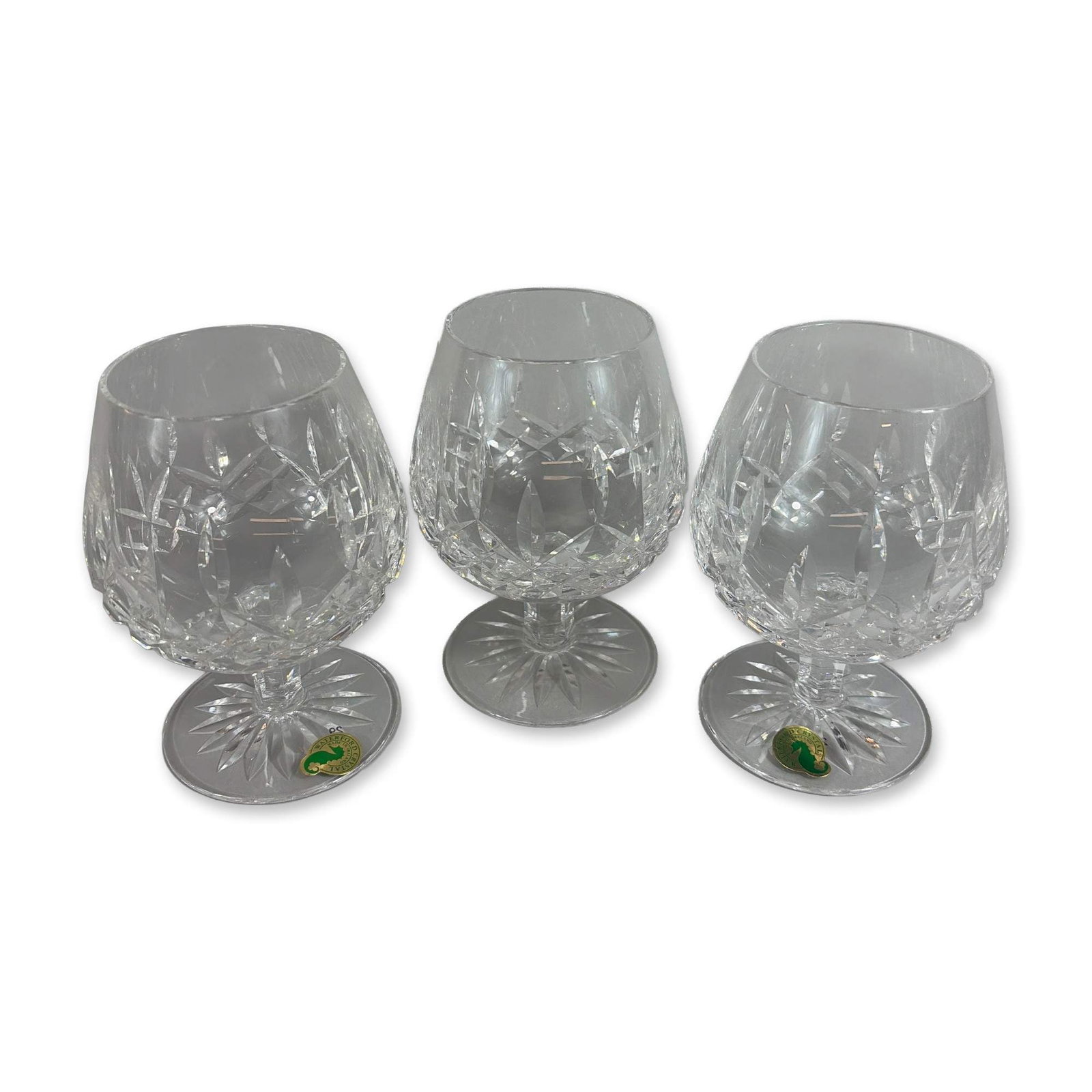 3pc Waterford Crystal Lismore Brandy Glasses: Waterford. Trio of brandy balloons in lead crystal, decorated in the Lismore pattern. Each piece features a rounded bowl with a band of deep diamond cuts surmounted by vertical wedge cuts. The vessels