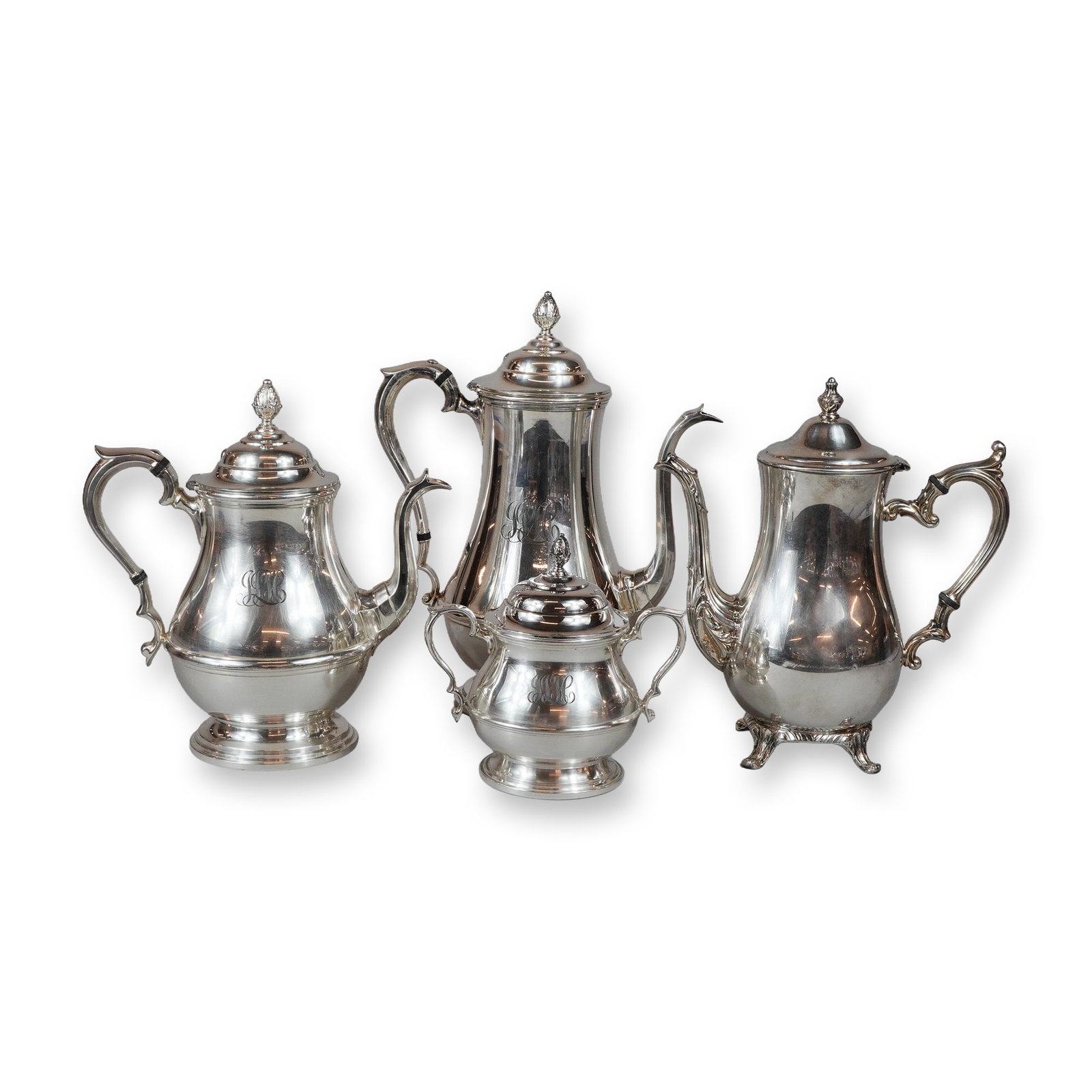 4pc Reed & Barton and Wm Rogers Silver-Plated Tea and Coffee Pots and Sugar Bowl: Collection includes a three-piece silver-plated cafe ware set by Reed & Barton in the Betsy Ross pattern, comprising a coffee pot, tea pot, and covered sugar bowl. Each piece features an engraved mono