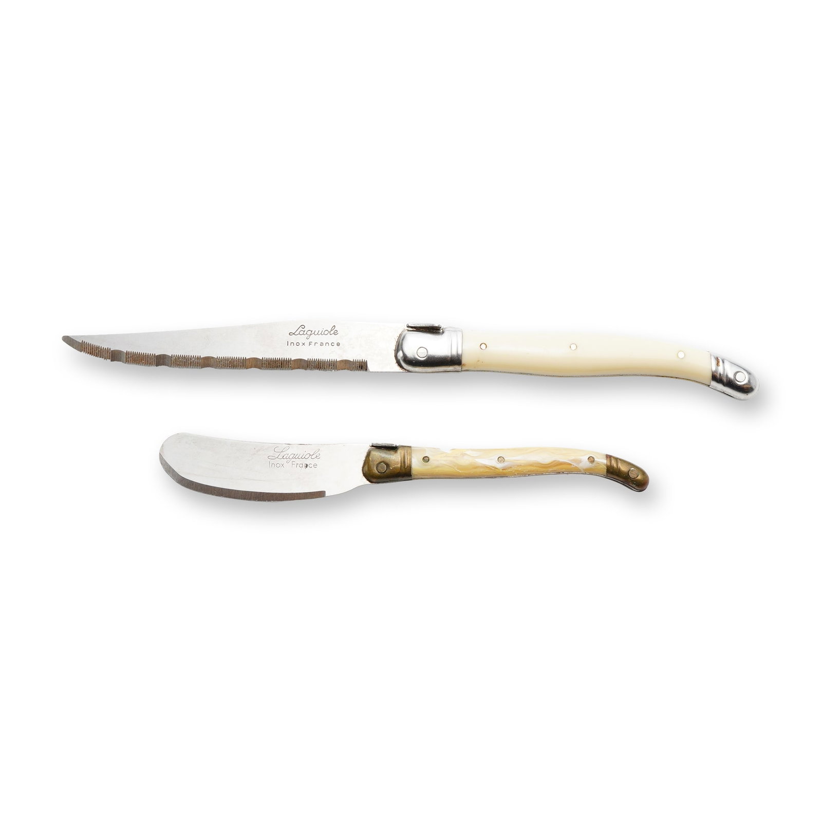 Two Laguiole Inox France Specialty Knives: Pair of Laguiole specialty knives including one long serrated knife with a pointed tip and one curved spreader. Both pieces feature stainless steel blades stamped with the maker's mark Laguiole and In