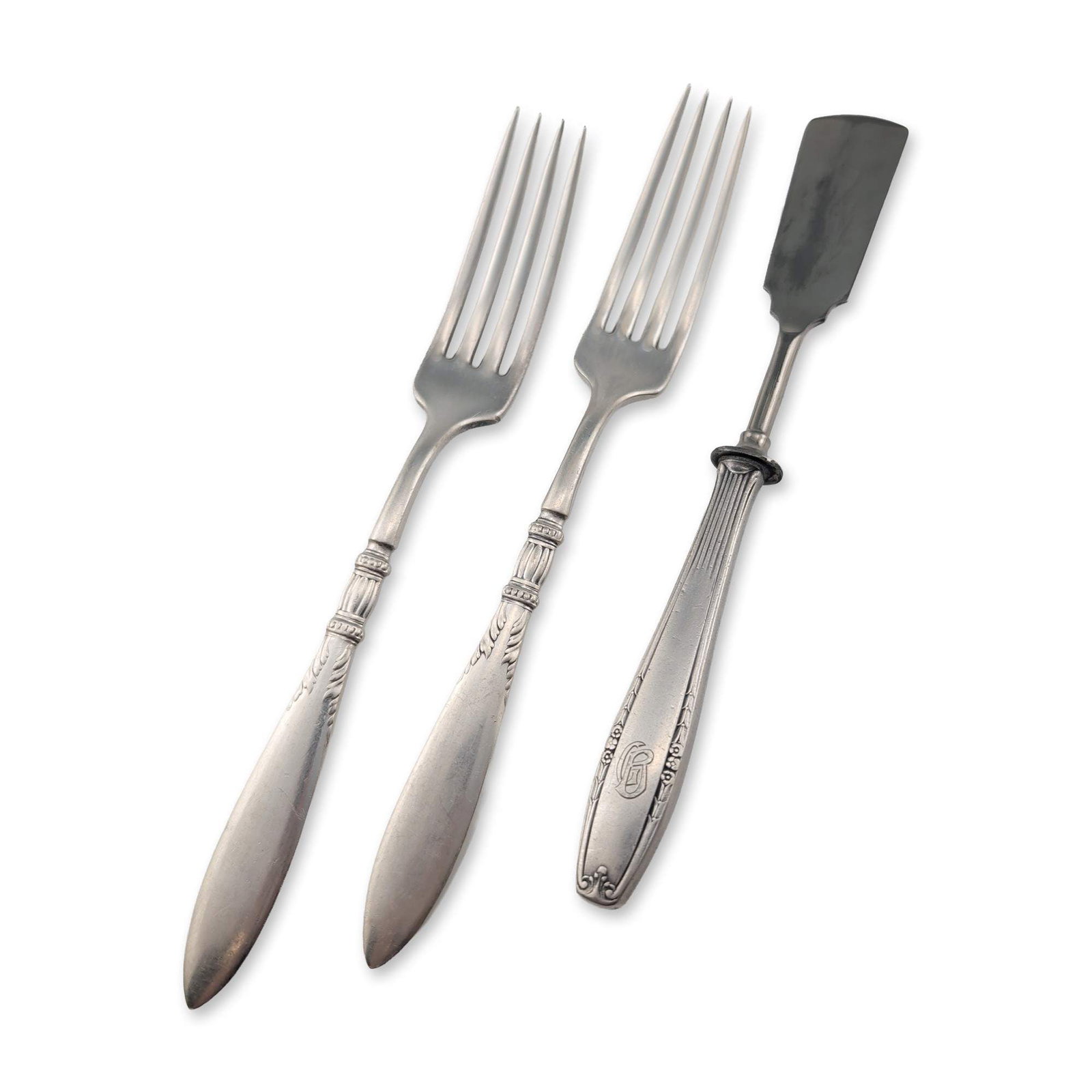 3pc 1847 Rogers Bros Silverplate Forks and Butter Knife: Trio of silverplate flatware pieces featuring a pair of forks and one butter knife. The pair of forks are characterized by a neoclassical fluted neck and and scroll motifs on a pointed handle. The