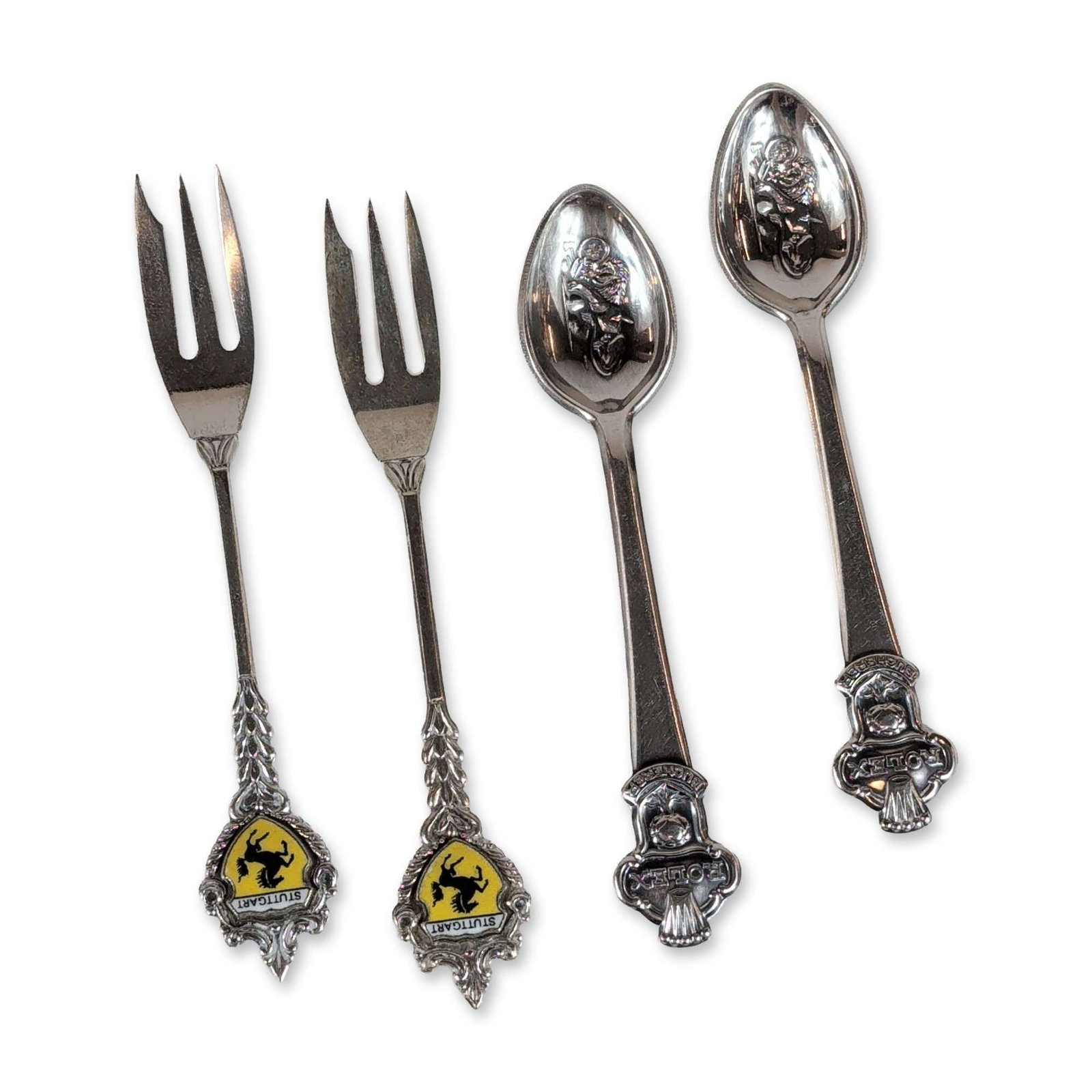 4pc Silver-Plated Souvenir Flatware: Collection of silver-plated souvenir flatware comprising two spoons and two forks. Includes two Rolex Bucherer spoons in the Lucerne pattern, featuring the Rolex coronet and Lion of Lucerne crest at t