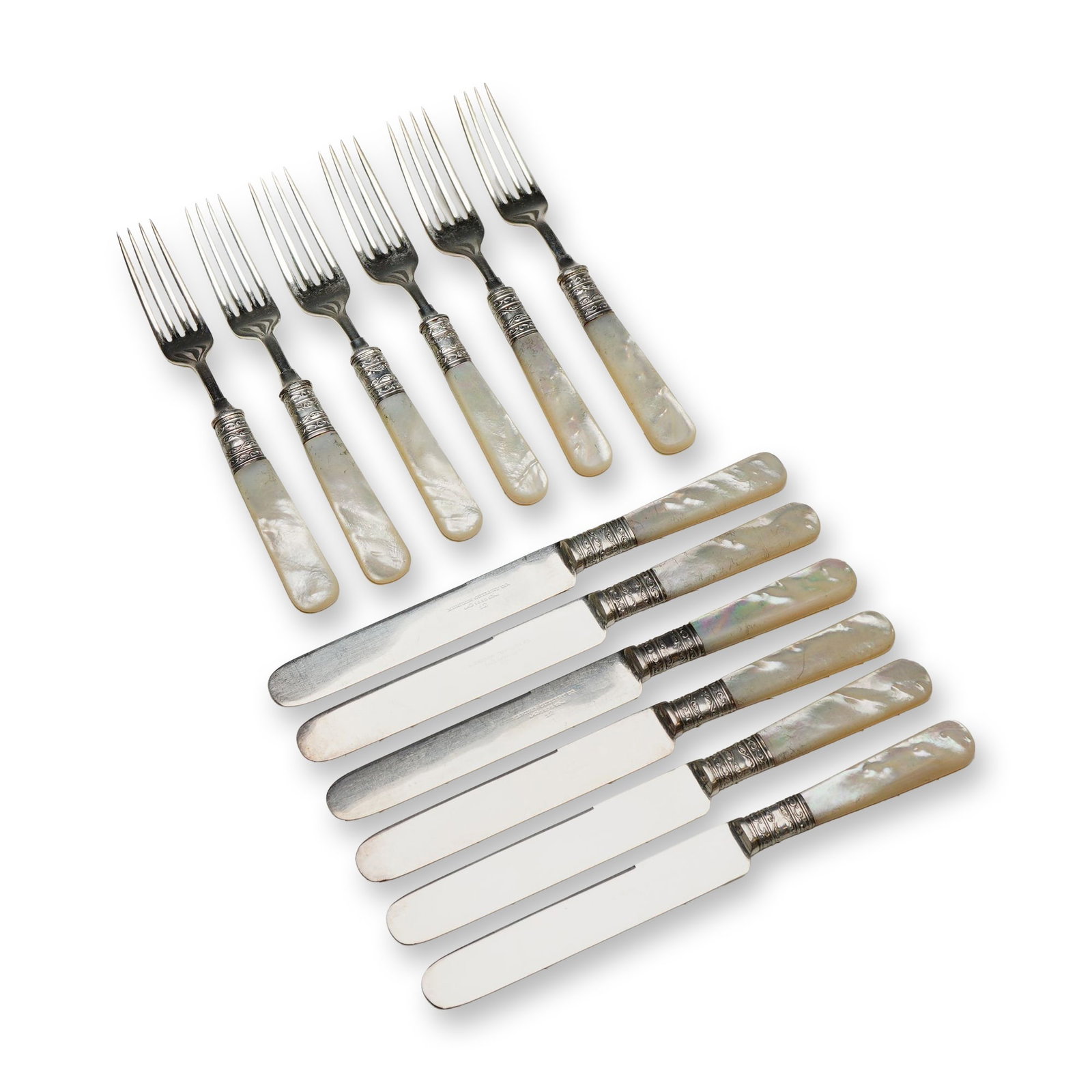 12-Piece Set of Meriden Cutlery Co. Mother of Pearl and Sterling Silver Flatware: Meriden Cutlery Co. American dessert or fruit flatware set featuring carved mother of pearl handles and sterling silver collars. The handles terminate in rounded, tapered ends and are joined to silver
