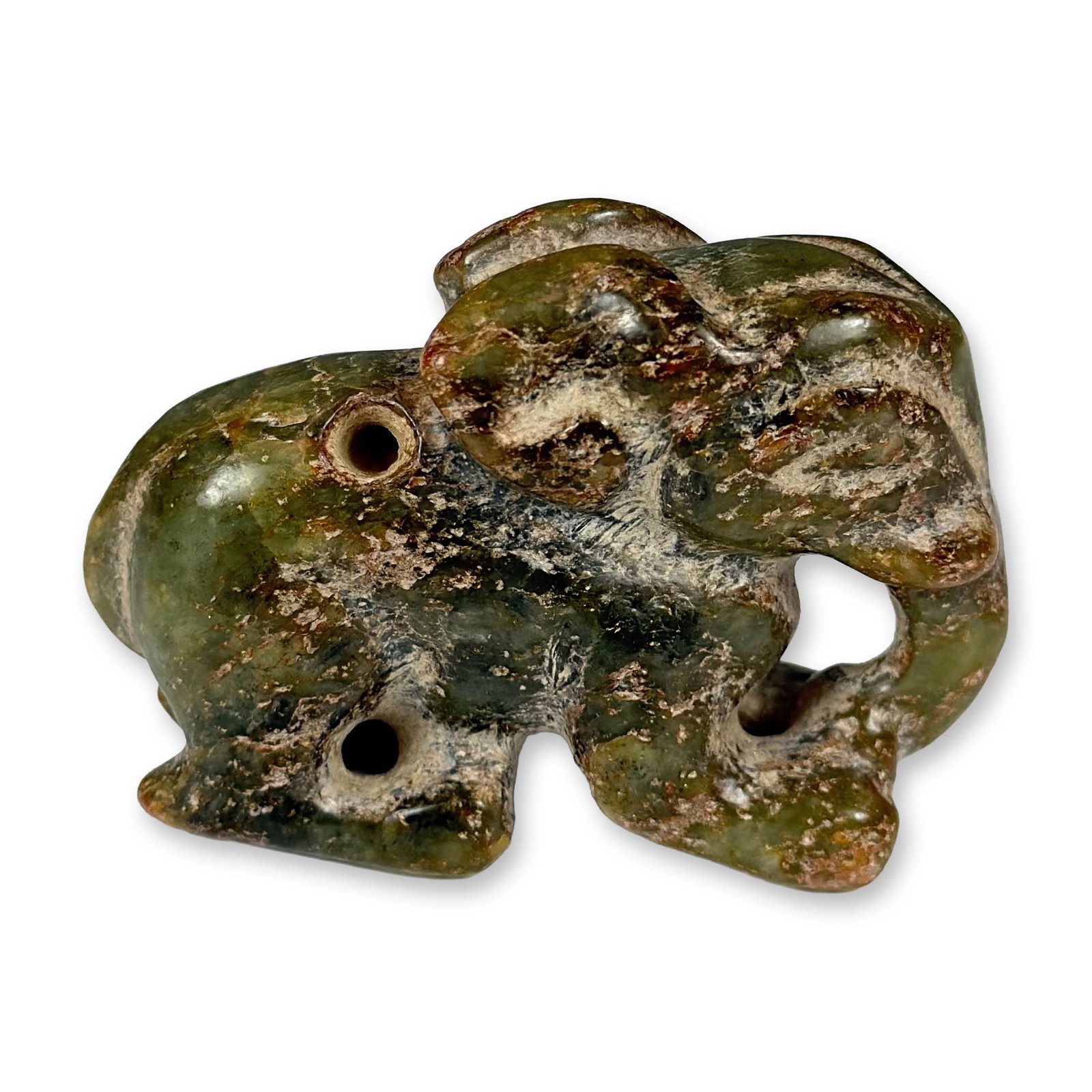 Chinese Hongshan Style Hand-Carved Greenish Hardstone Elephant Pendant: This hand-carved elephant pendant is crafted from a greenish stone featuring prominent brown inclusions, executed in the Chinese Hongshan style. The figurine depicts a recumbent elephant with simplifi