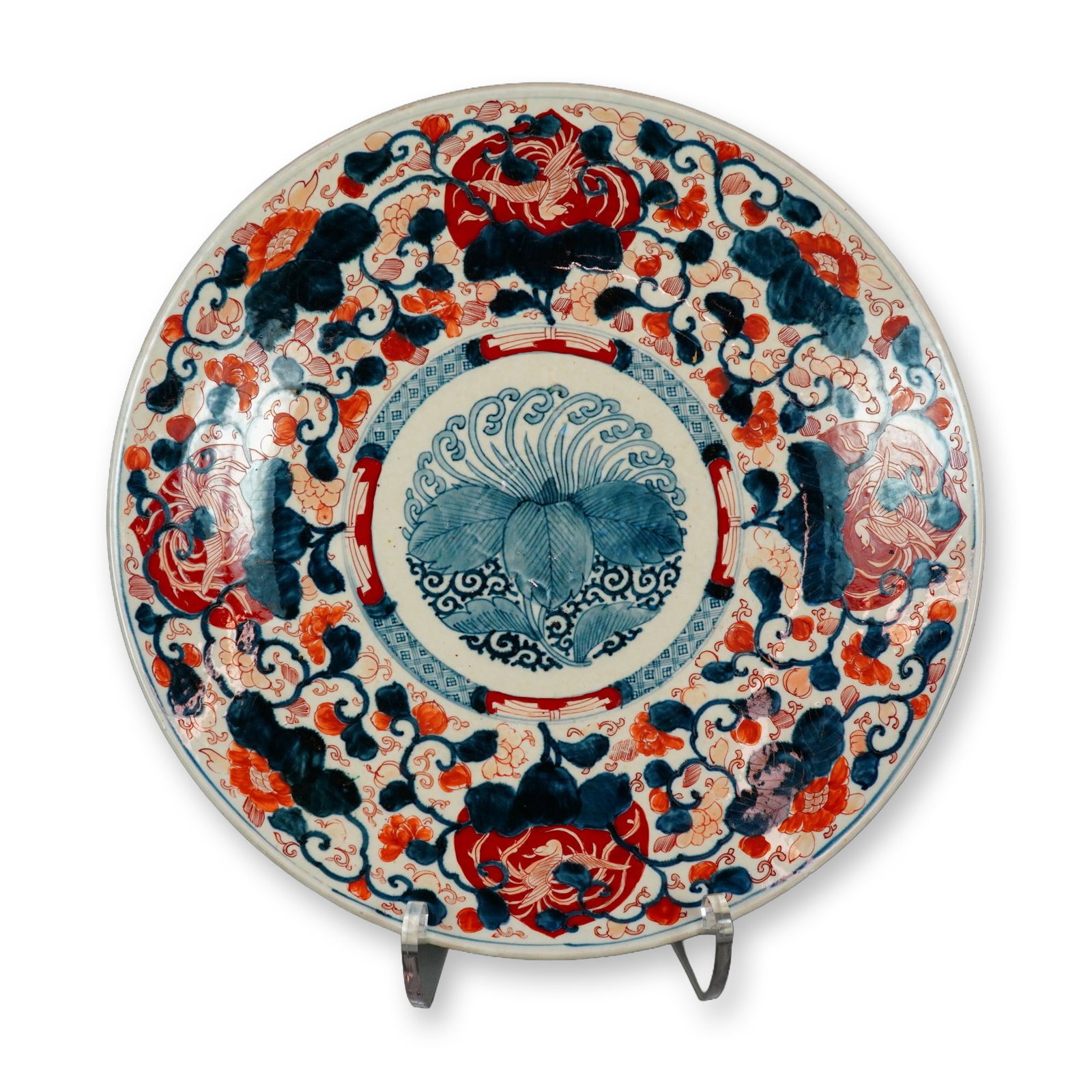 Monumental Japanese Imari Ceramic Centerpiece Bowl: Japanese Imari style shallow ceramic centerpiece bowl. The hand painted porcelain charger features a central circular medallion depicting a stylized pomegranate with scrolling foliate designs, surroun