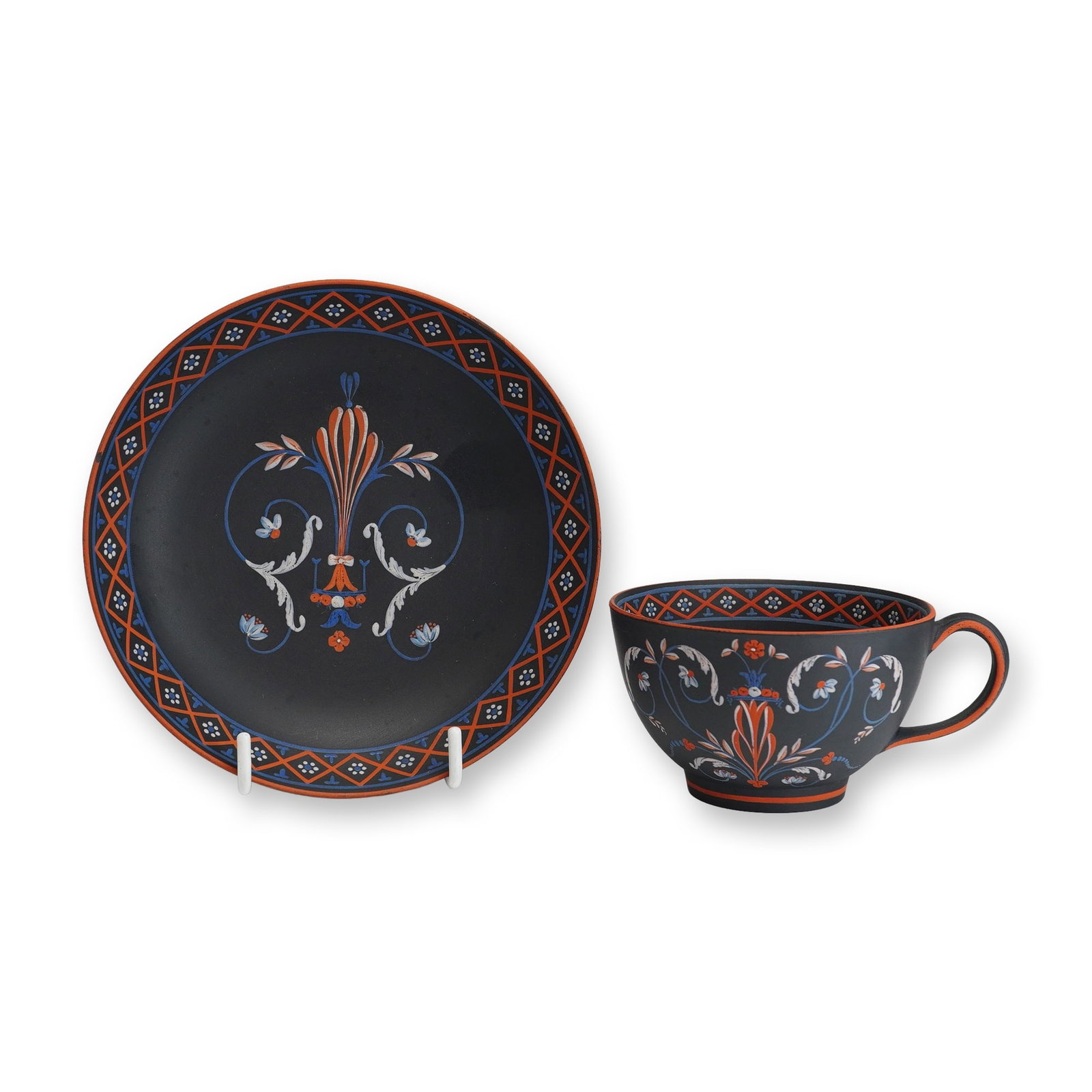 2pc Wedgwood Black Basalt Enamelled Teacup and Saucer: This set consists of a Wedgwood black basalt teacup and matching saucer, featuring hand-painted polychrome encaustic-style enamel decoration. The pieces are constructed from fine-grained, unglazed bla