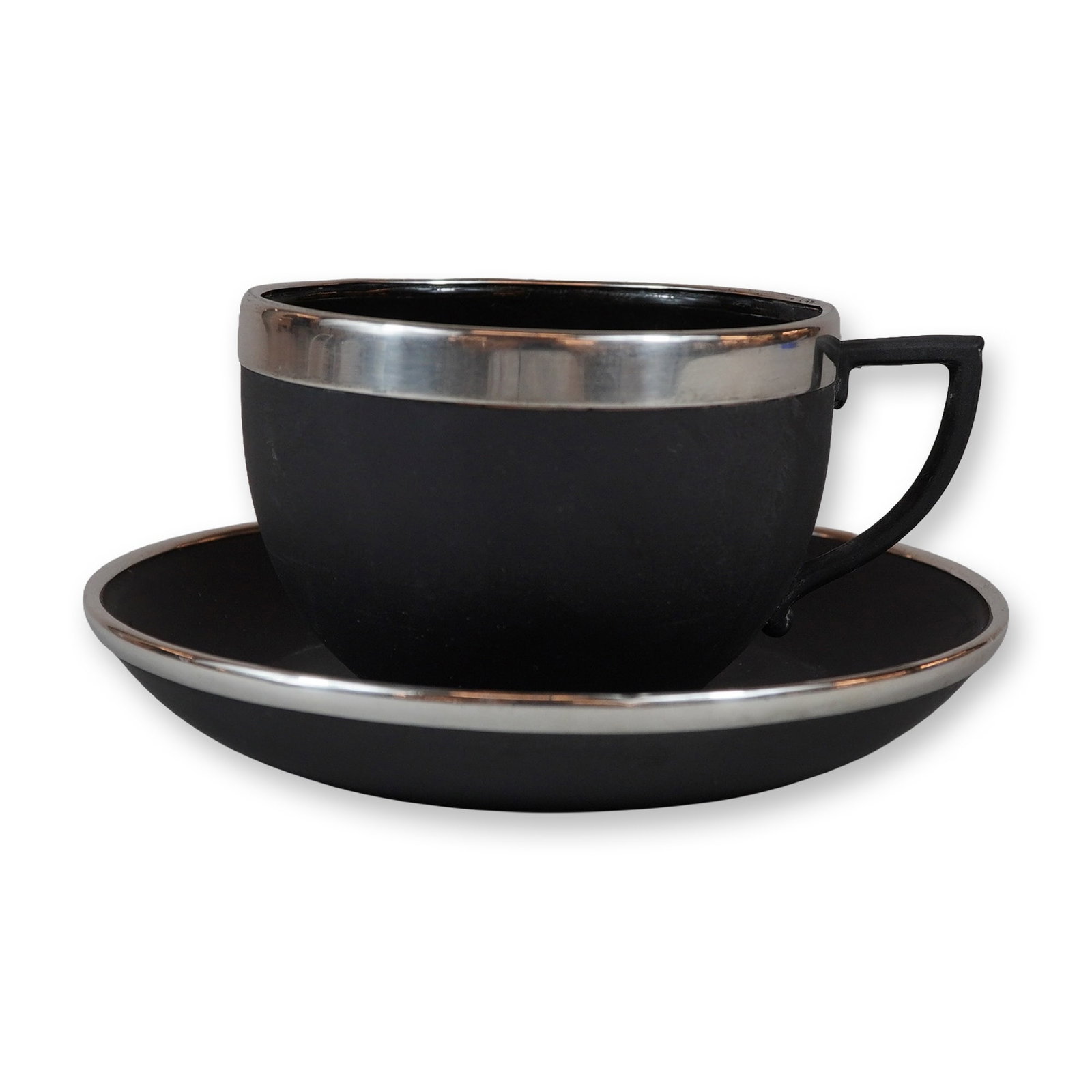 2pc Wedgwood Black Basalt Teacup and Saucer with Sterling Silver Mounts: This set comprises a black basalt teacup and matching saucer made by Wedgwood in Staffordshire, England. The pieces are made from fine matte black stoneware and feature sterling silver bands around th