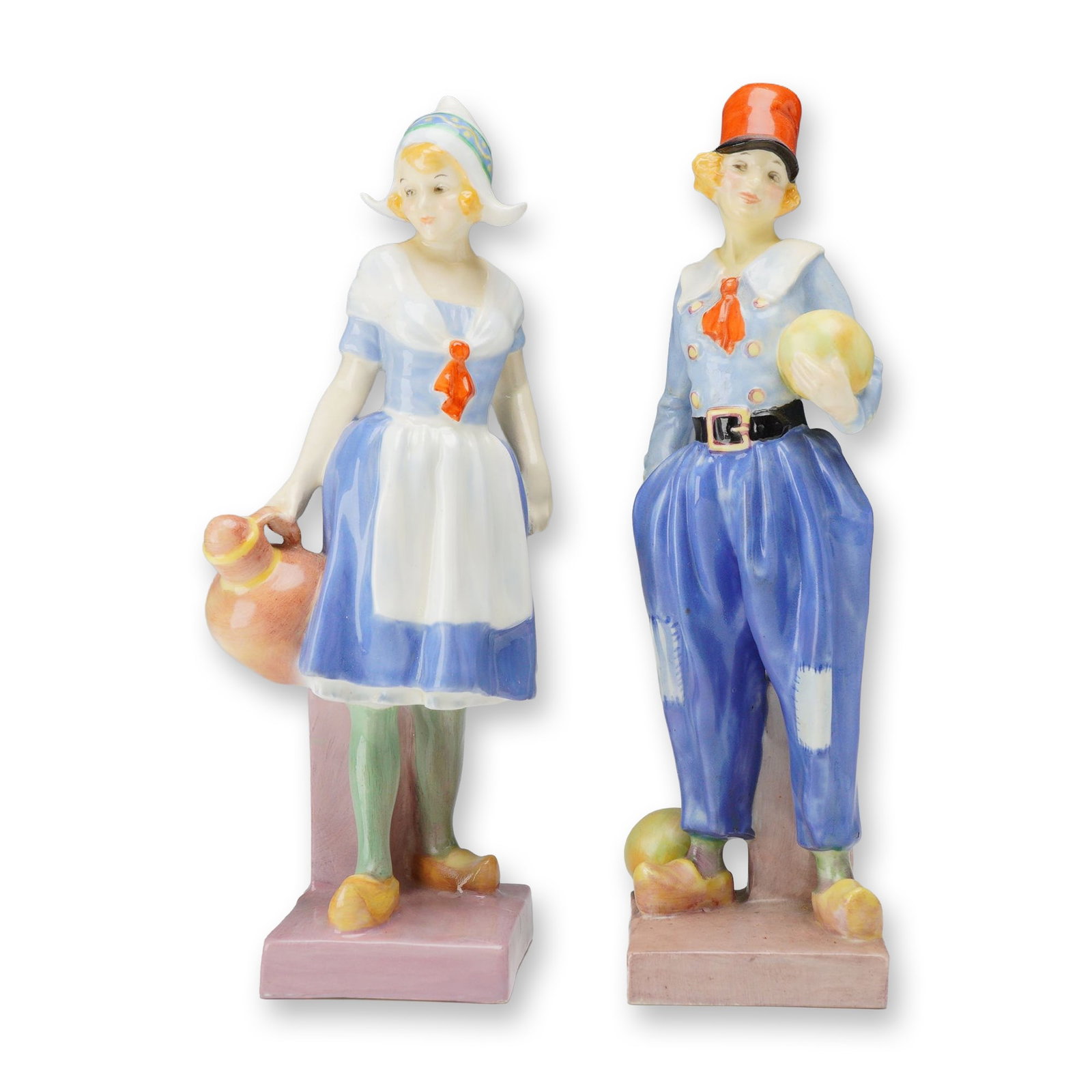 Pair of Royal Doulton Porcelain Figurines, Gretchen HN1397 and Derrick HN1398: Depicting children in traditional Dutch costume. Gretchen is modeled wearing a blue dress, white apron, and pointed Dutch cap while holding an earthenware jug. Derrick wears wide patched blue trousers