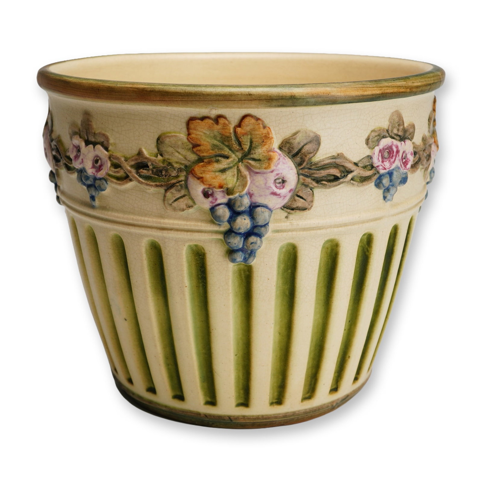 Weller Pottery Creamware Jardiniere, Flemish: The vessel features a continuous polychrome frieze depicting grapevines with clusters and roses rendered in shades of blue, purple, pink, and green against a cream-colored ground. The lower body is