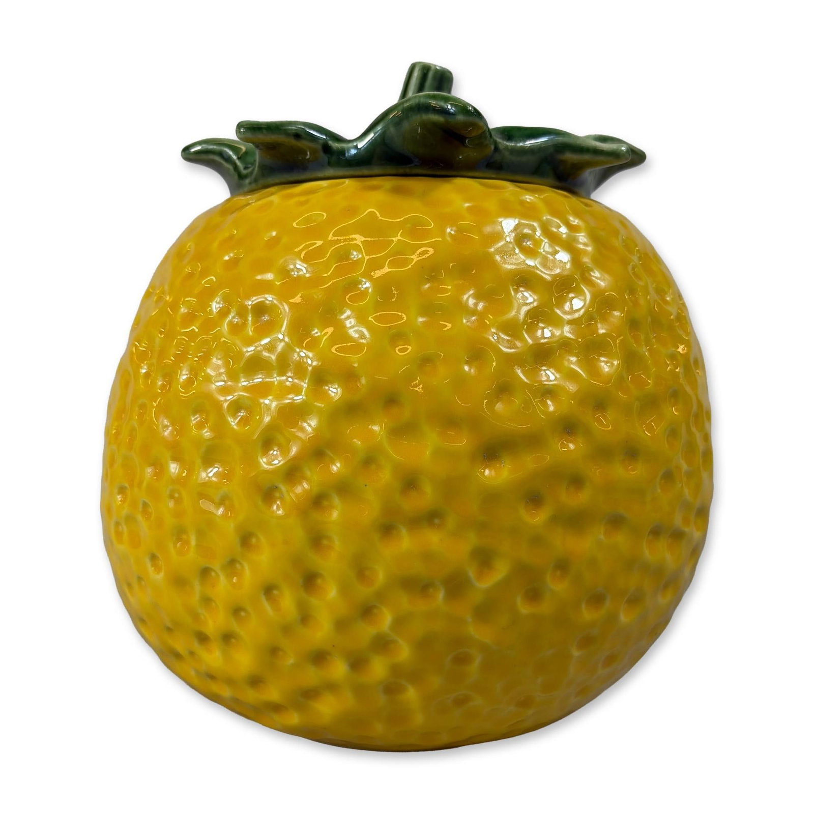 McCoy Ceramic Glazed Earthenware Lemon Jar: Lidded storage jar or canister in glazed earthenware, modeled in the form of a stylized lemon. The spherical body features a dimpled texture throughout, finished in a bright yellow glaze. Accompanied 