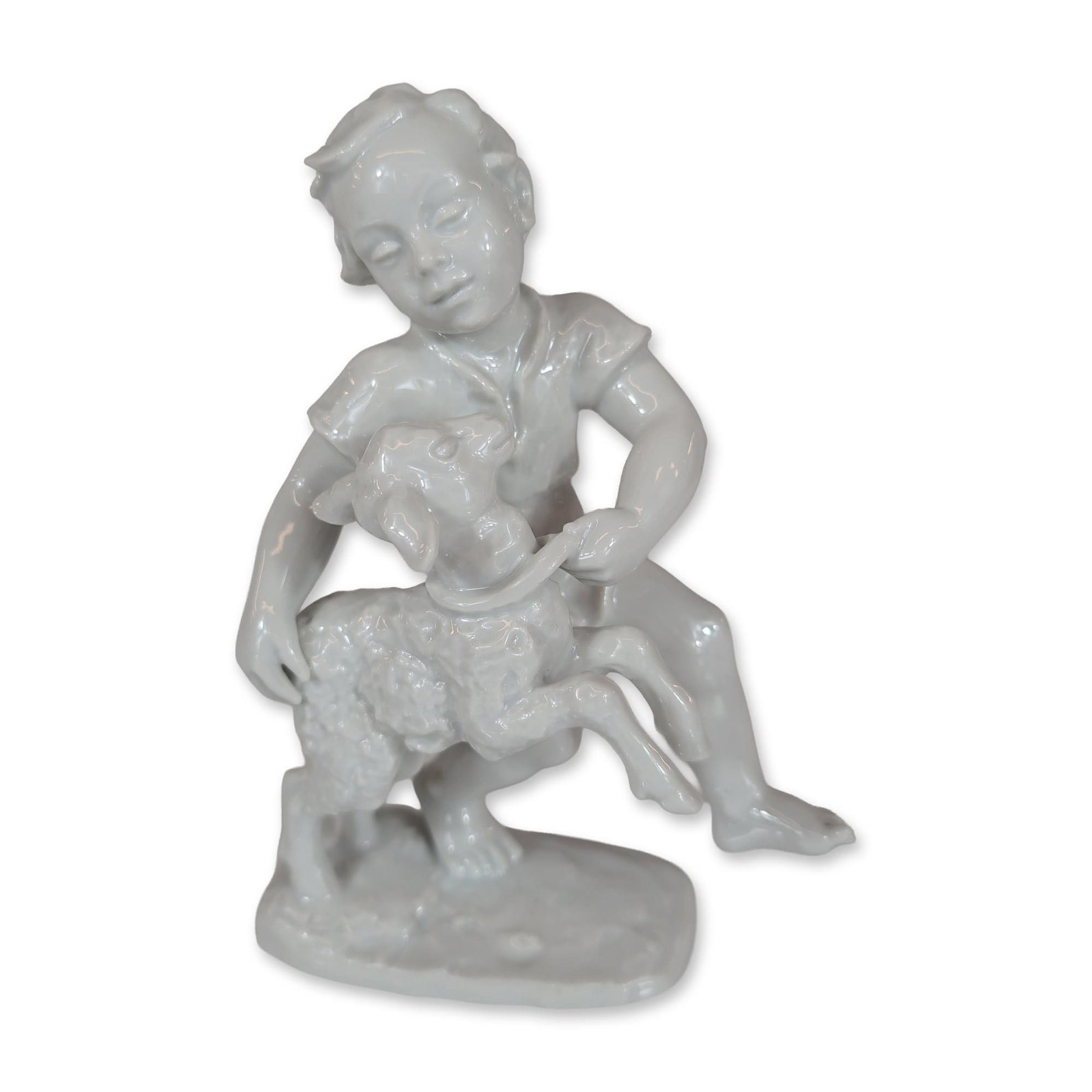 Rosenthal Figurine by Lore Friedrich-Gronau, Boy with Lamb: Rosenthal white glazed porcelain figurine designed by Lore Friedrich-Gronau. The figure depicts a young boy wearing a short-sleeved shirt and shorts kneeling on a textured, naturalistic base while hol