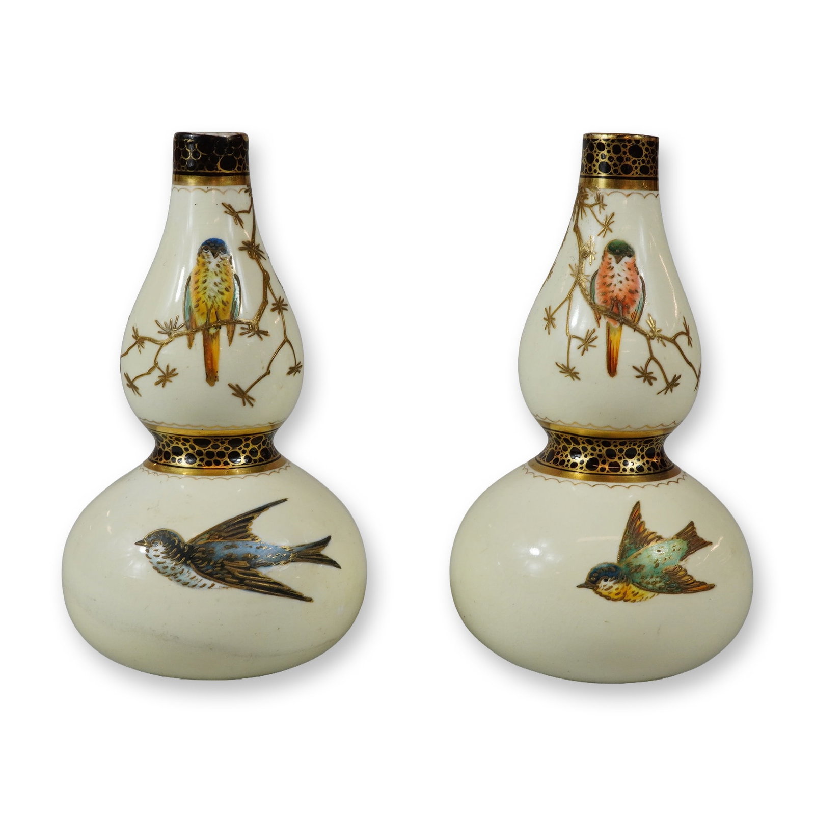 Pair of Wedgwood Bone China Gilt Paste and Enameled Bird Small Vases: This pair of Wedgwood porcelain double-gourd vases, each features an off-white cream glaze with hand-painted birds. The upper bulbs depict birds perched on delicate gilded branches, while the lower bu