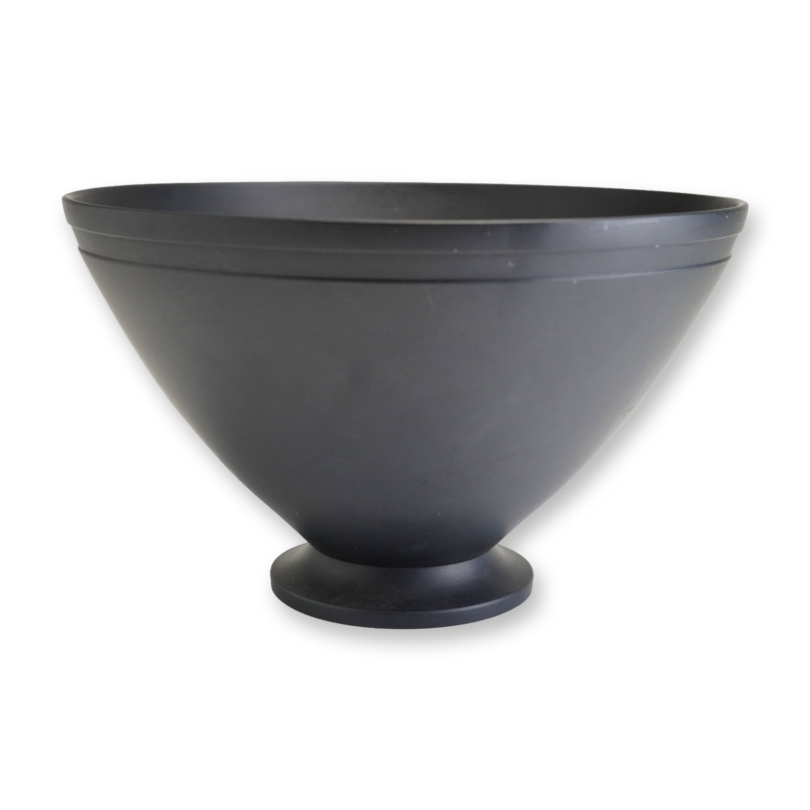 Keith Murray for Wedgwood Black Basalt Footed Bowl: This black basalt footed bowl was designed by Keith Murray for Wedgwood. The piece is constructed from fine-grained, unglazed black stoneware and features a conical body with a slightly flared rim, su