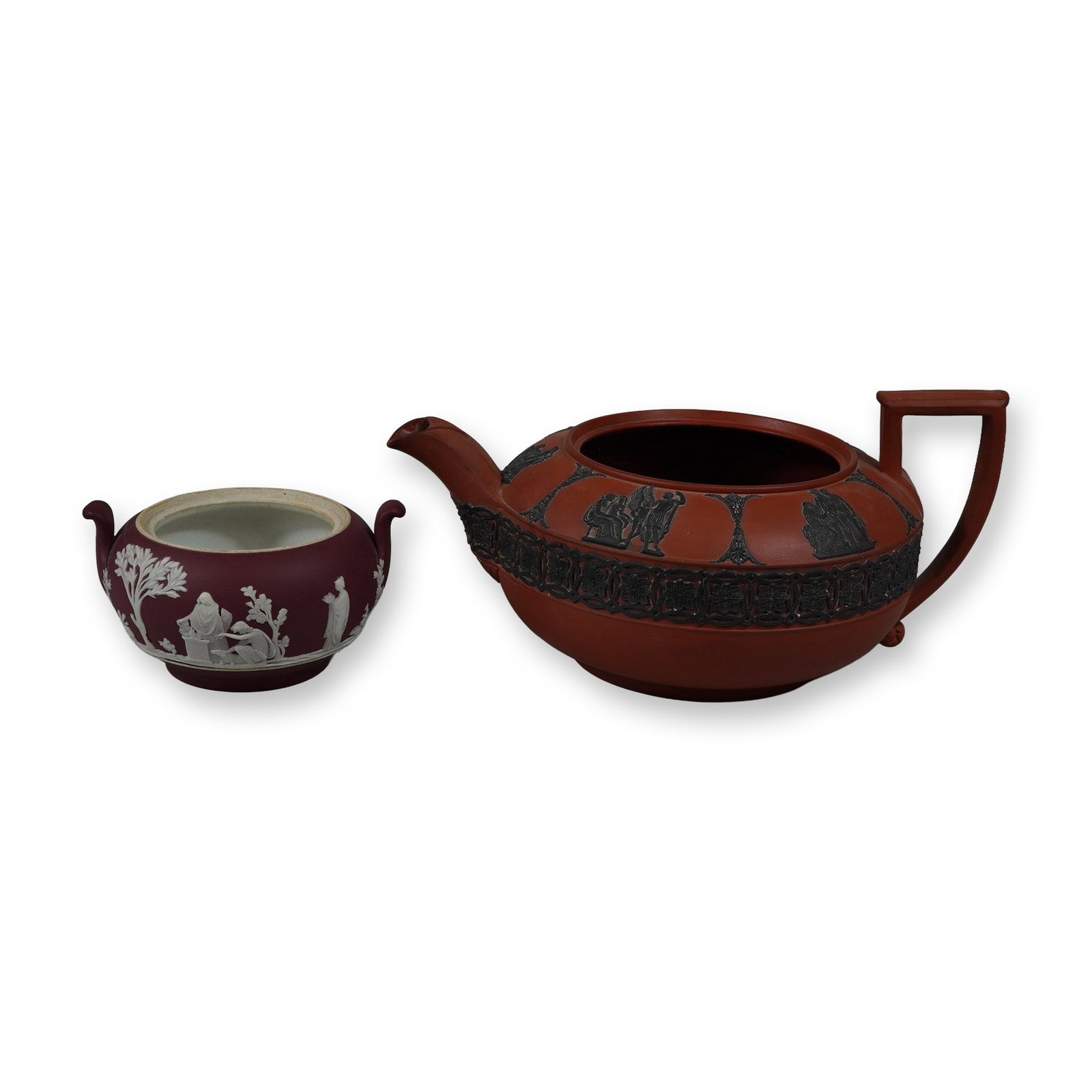 2pc Wedgwood Jasperware Vessels including Rosso Antico and Crimson Dip: This lot consists of two Wedgwood stoneware vessels. Included is one Rosso Antico teapot base and one crimson dip jasperware sugar bowl base. The Rosso Antico teapot is made of red stoneware with appl