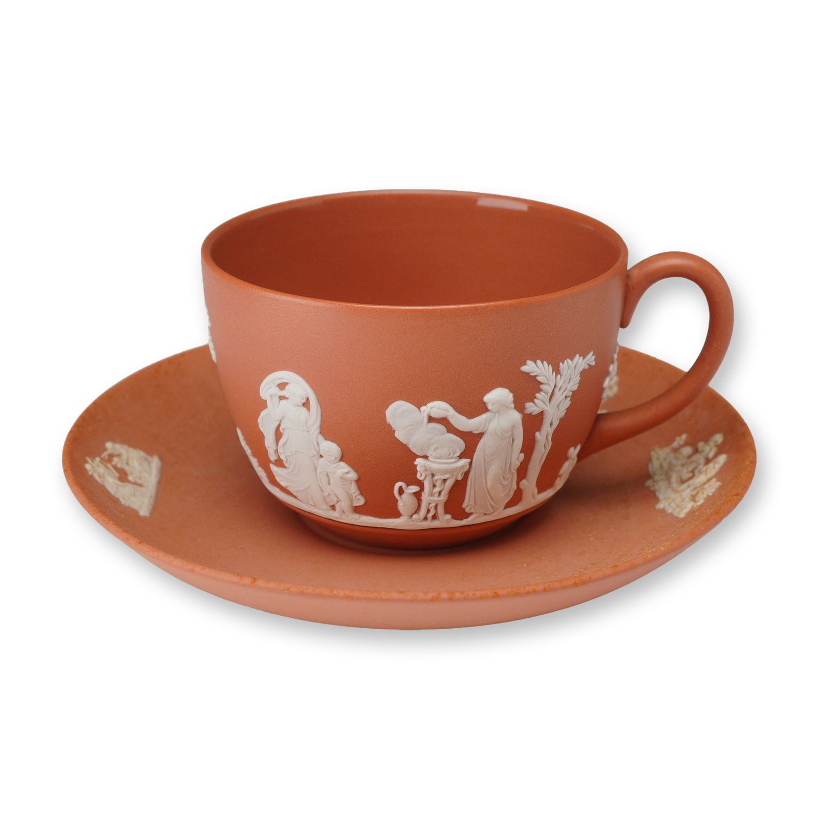 2pc Wedgwood Terracotta Jasperware Cup and Saucer Set: A Wedgwood cup and matching saucer crafted in terracotta-colored jasperware, a fine-grained unglazed stoneware. This set features a reddish-brown body decorated with applied white stoneware bas-relief