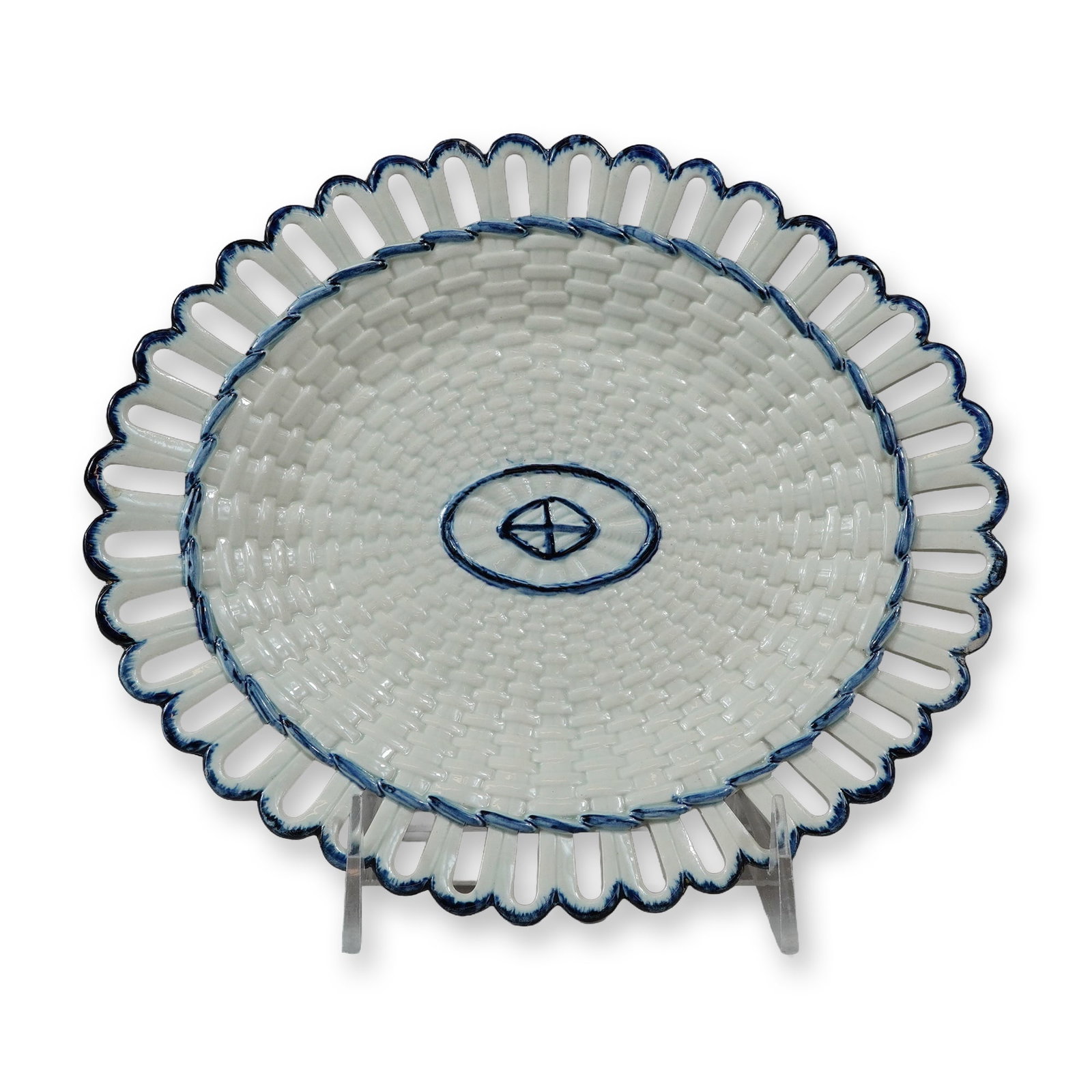 Wedgwood Pearlware Reticulated Basket-Weave Oval Plate: The dish features a molded basket-weave texture in the central well and a flared, reticulated rim composed of a series of pierced arches. Decoration consists of hand-painted underglaze blue detailing,