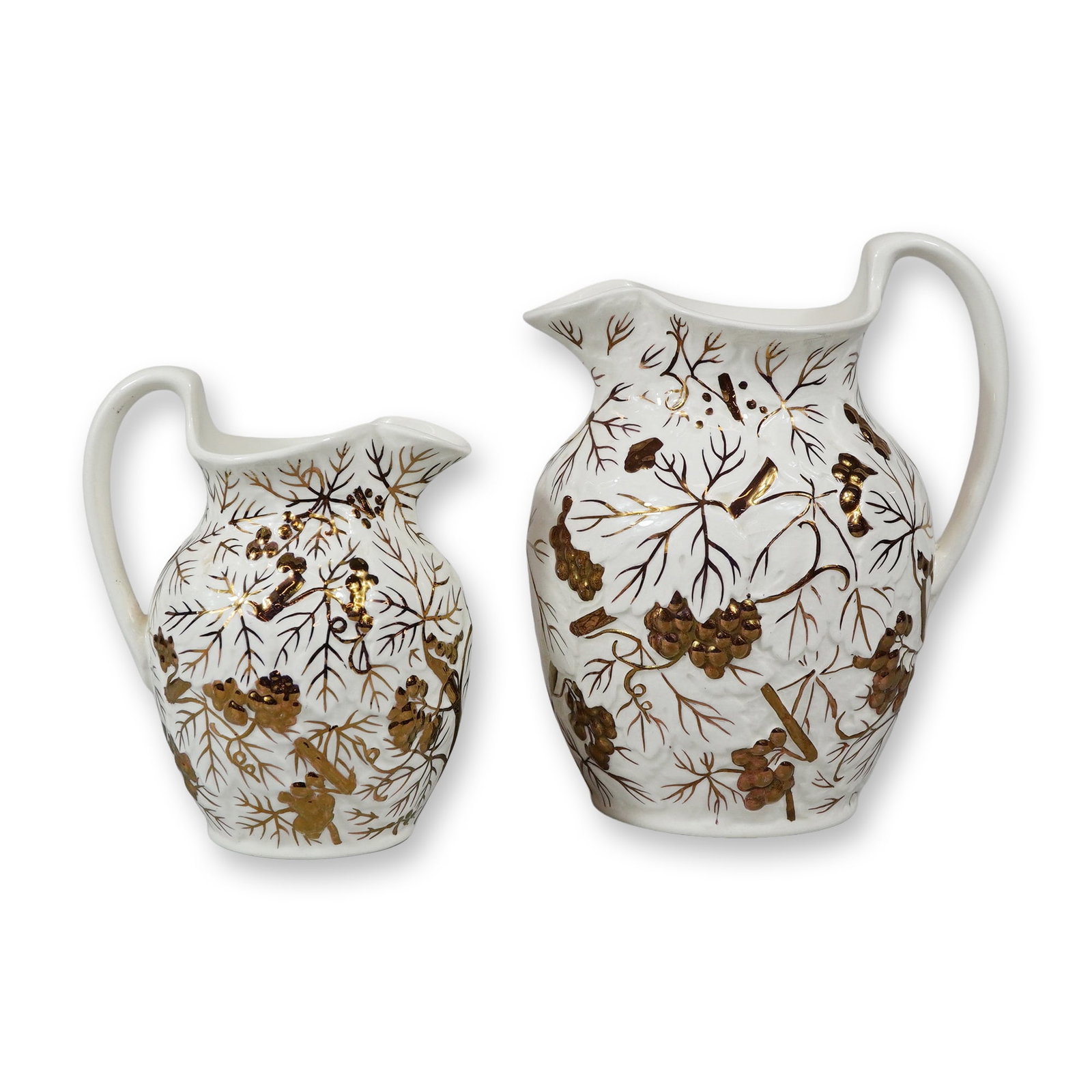 A Pair of Wedgwood Barlaston White and Gold Luster Pitchers, Fern & Berry: The bodies feature a relief-molded grapevine pattern where the berry clusters and leaves are accented with a metallic copper-colored luster. Hand-painted brown lines depict the vine branches and tendr