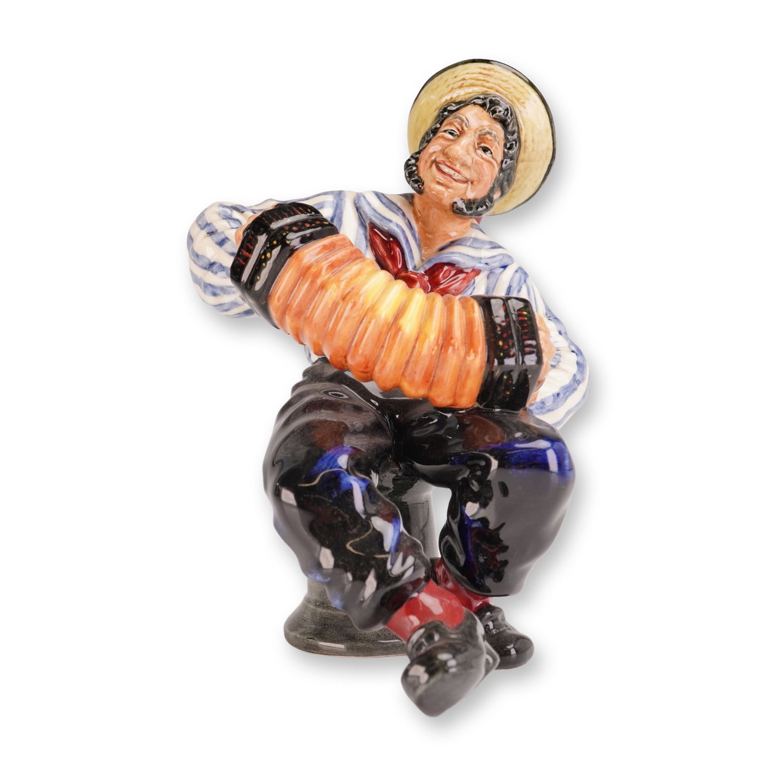 Royal Doulton Porcelain Figurine, Jolly Sailor HN2172: Designed by Mary Nicoll. The hand-painted figure depicts a seated sailor in a blue and white striped shirt, red neckerchief, wide-brimmed straw hat, and black trousers, playing an orange accordion whi