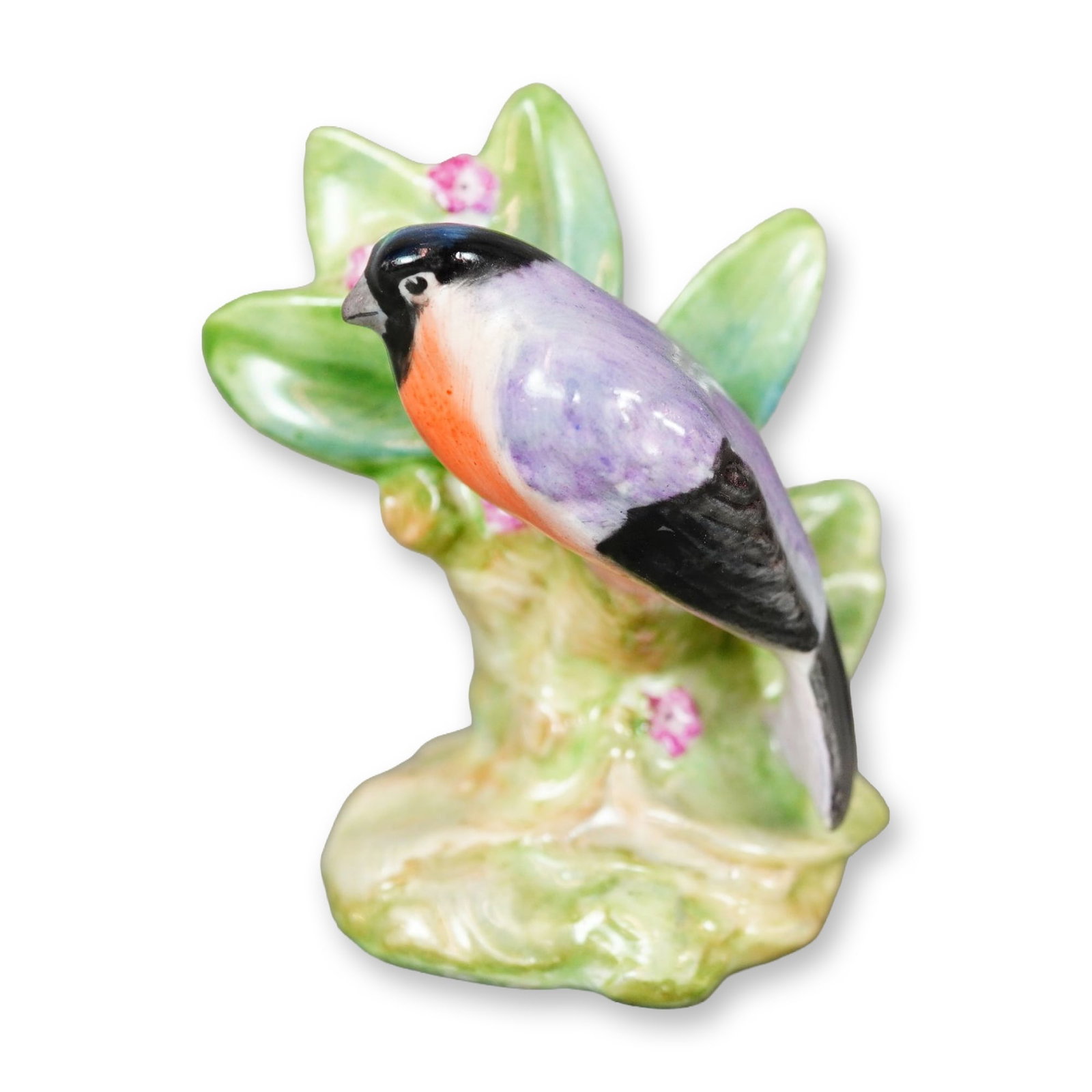 Royal Doulton Bone China Bird Figurine, Bullfinch K31: Hand-painted figure of a bird featuring a purple body, a soft light-red chest, and black coloring on the head, wings, and tail feathers. The bird is shown perched beside pink flowers. Royal Doulton ba