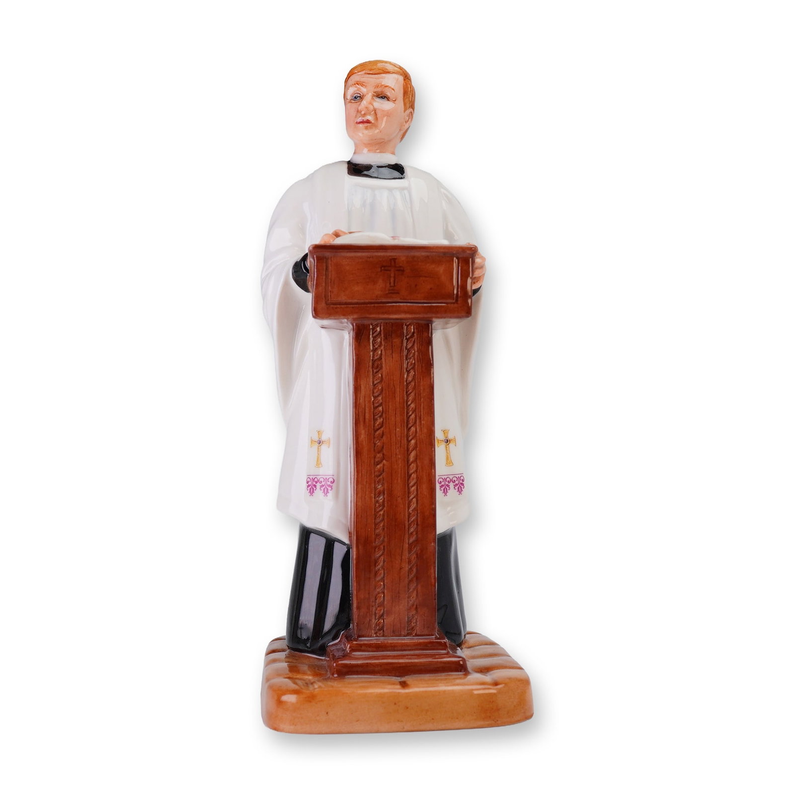 Royal Doulton Prototype Figurine, Vicar: English porcelain figurine of a vicar at a pulpit with an open book, finished in glaze and wearing a black cassock, white surplice, and white stole with gilt crosses and pink floral accents. Underside
