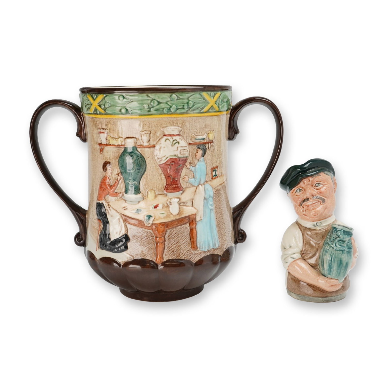 2pc Royal Doulton Pottery In The Past Loving Cup (D6696) and Albert Sagger The Potter (D6745): Royal Doulton glazed earthenware commemorative group of two pieces produced exclusively for the International Royal Doulton Collectors Club. The first item is a Pottery in the Past loving cup, designe