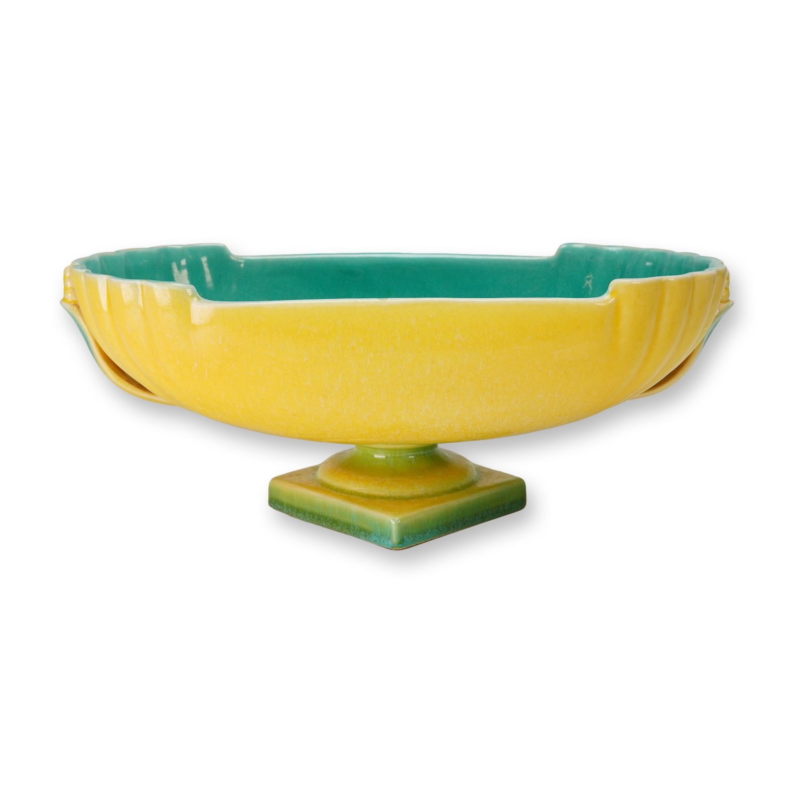 Roseville Pottery Orian Console Bowl: The vessel features an elongated oval form with a fluted exterior and stylized integral handles. It is decorated in a striking bi-color scheme, featuring a bright yellow mottled glaze on the exterior 