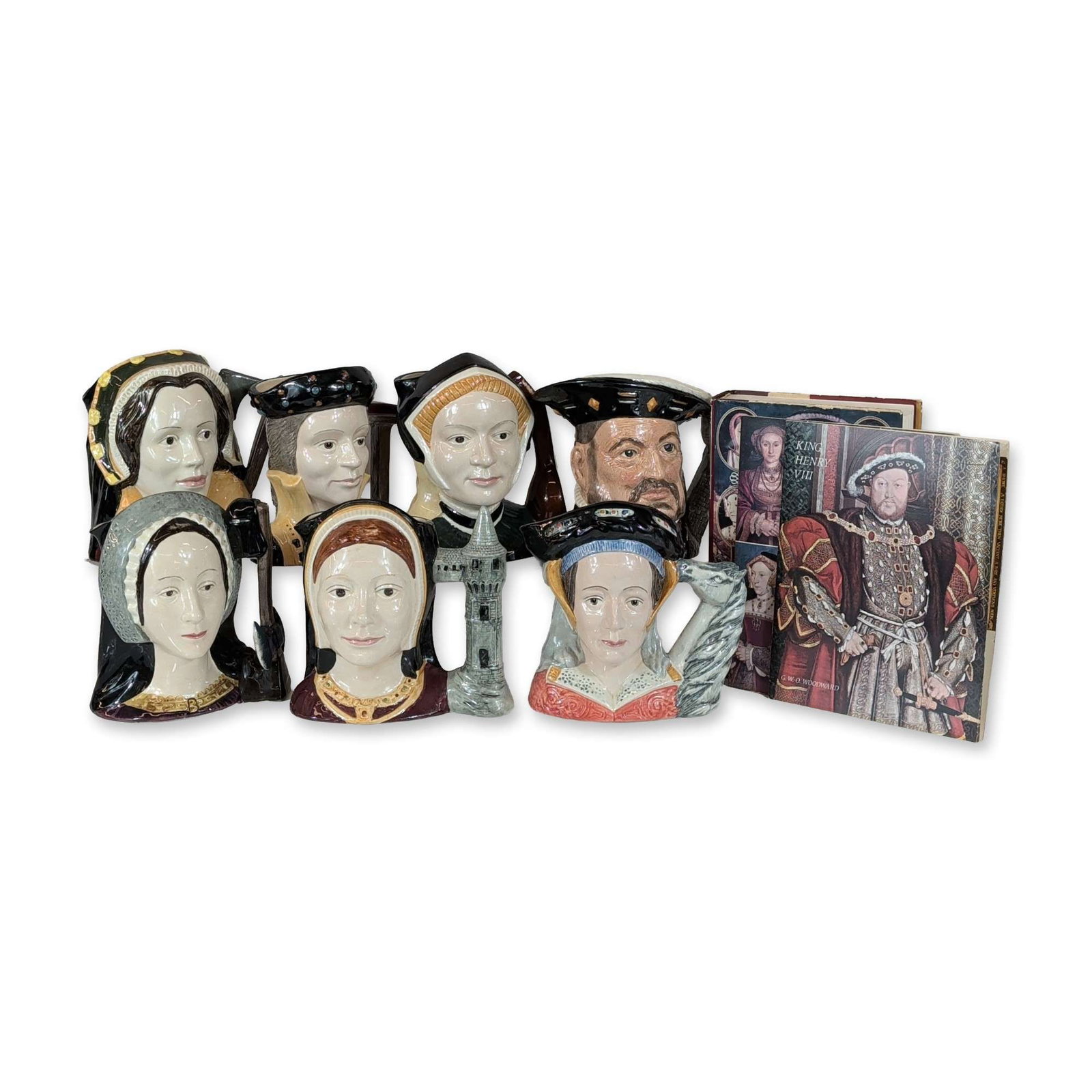 10pc Royal Doulton Henry VIII and Wives Collection: Royal Doulton, England. Collection of glazed ceramic character jugs and historical literature. The ceramic assembly features King Henry VIII and his six wives: Catherine of Aragon, Anne Boleyn, Jane S