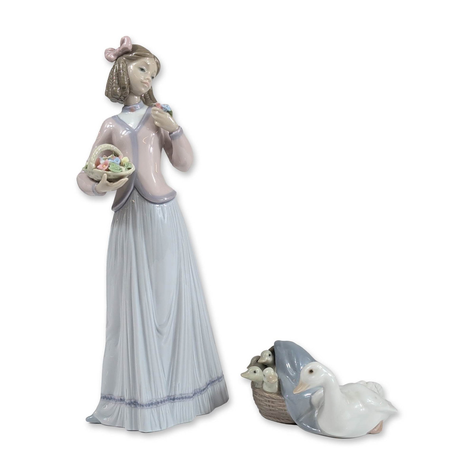 2pc Lladro Porcelain Figurines, 4895 and 7644: Lladro (Spain). Two glazed porcelain figurines including Innocence in Bloom (model 7644) and a duck family Duckling model 4895. The Innocence in Bloom figure depicts a young woman in a lavender bodice