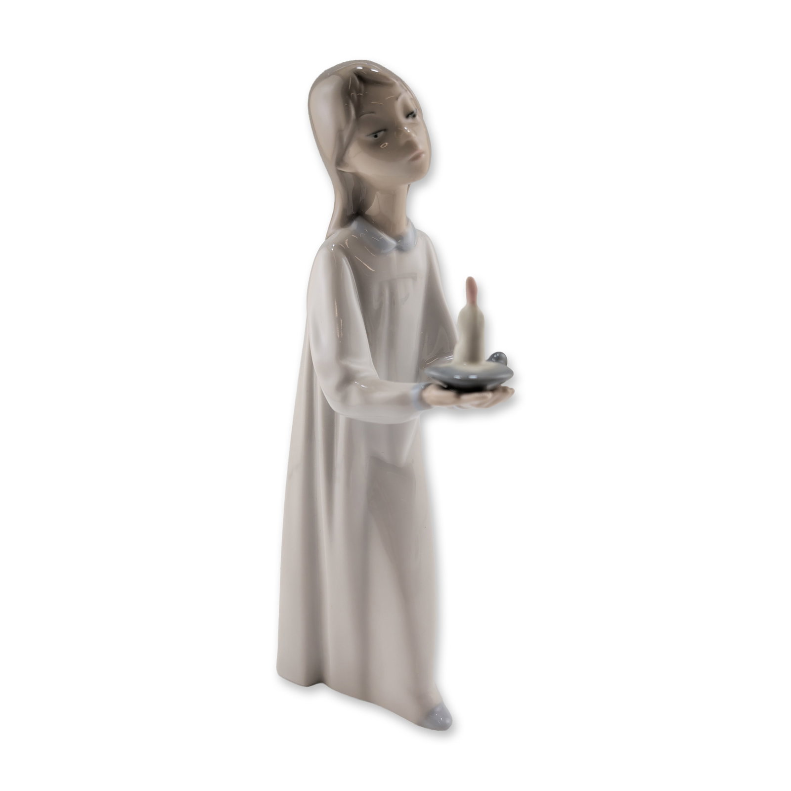 Lladro Porcelain Figurine, Girl with Candle 01004868: Lladro (Spanish, 20th century). Figurine in glazed porcelain titled Girl with Candle (Nina con Palmatoria), designed by Fulgencio Garcia and first issued in the early 1970s. The piece depicts a standi