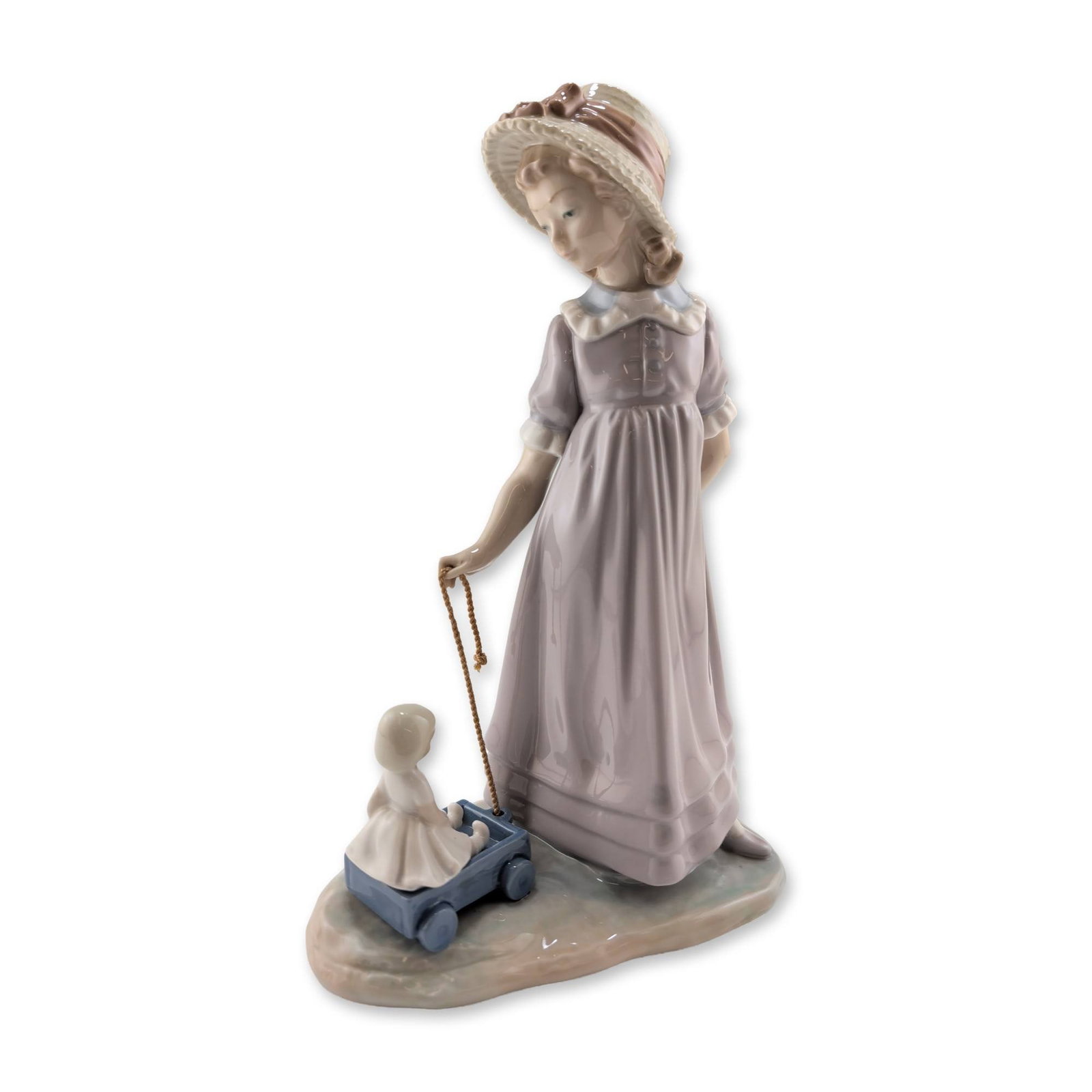 Lladro Girl with Toy Wagon Figurine 01005044: Lladro. Glazed porcelain figurine titled Girl with Toy Wagon, model number 5044. The piece depicts a young girl in a lavender long-sleeved dress with a white ruffled collar and a wide-brimmed straw ha