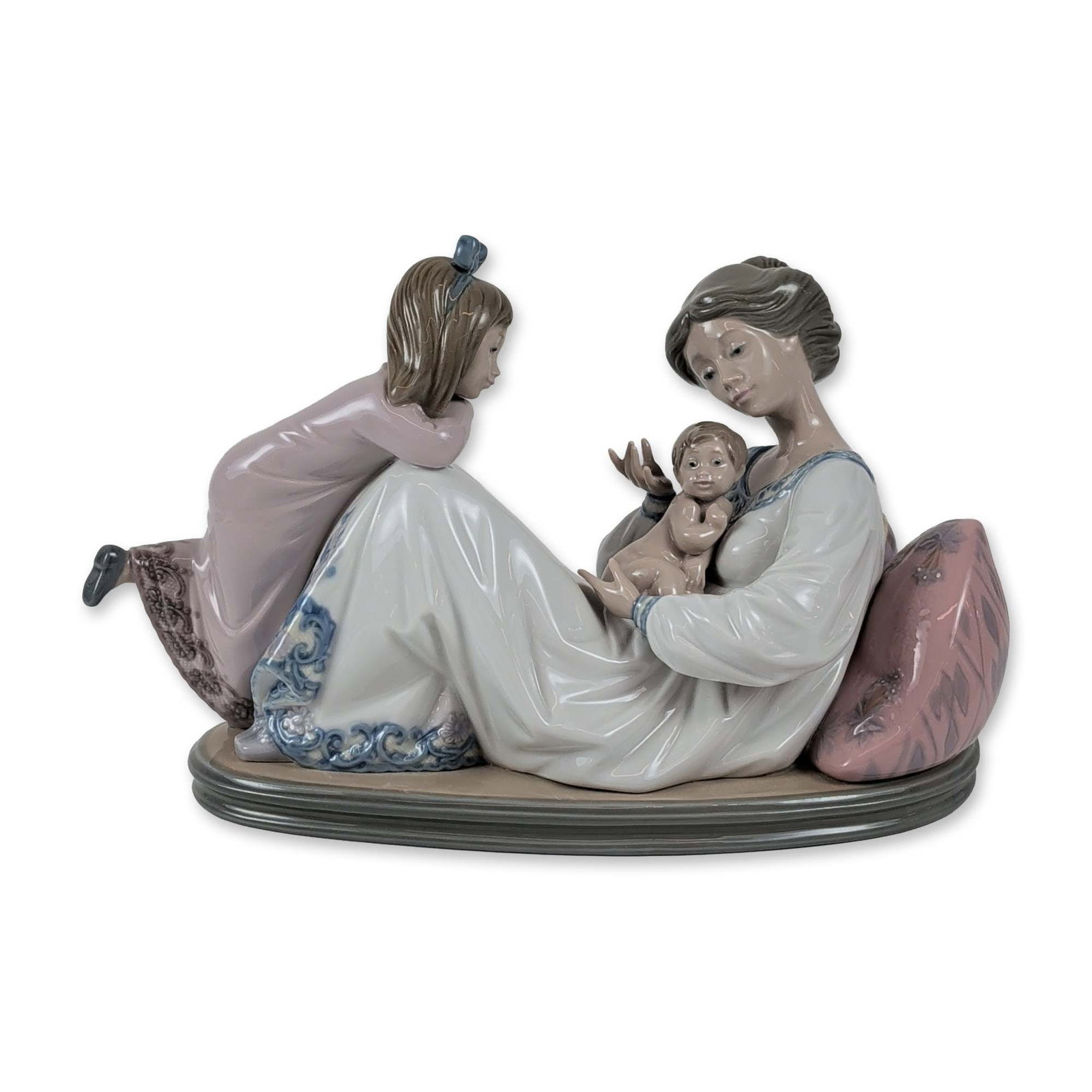Lladro Porcelain Figurine, Latest Addition 1001606: Lladro, Spain. Latest Addition, model number 1606, figurine in polychrome glazed porcelain. The composition depicts a domestic scene with a mother reclining against large floral-patterned pillows whil