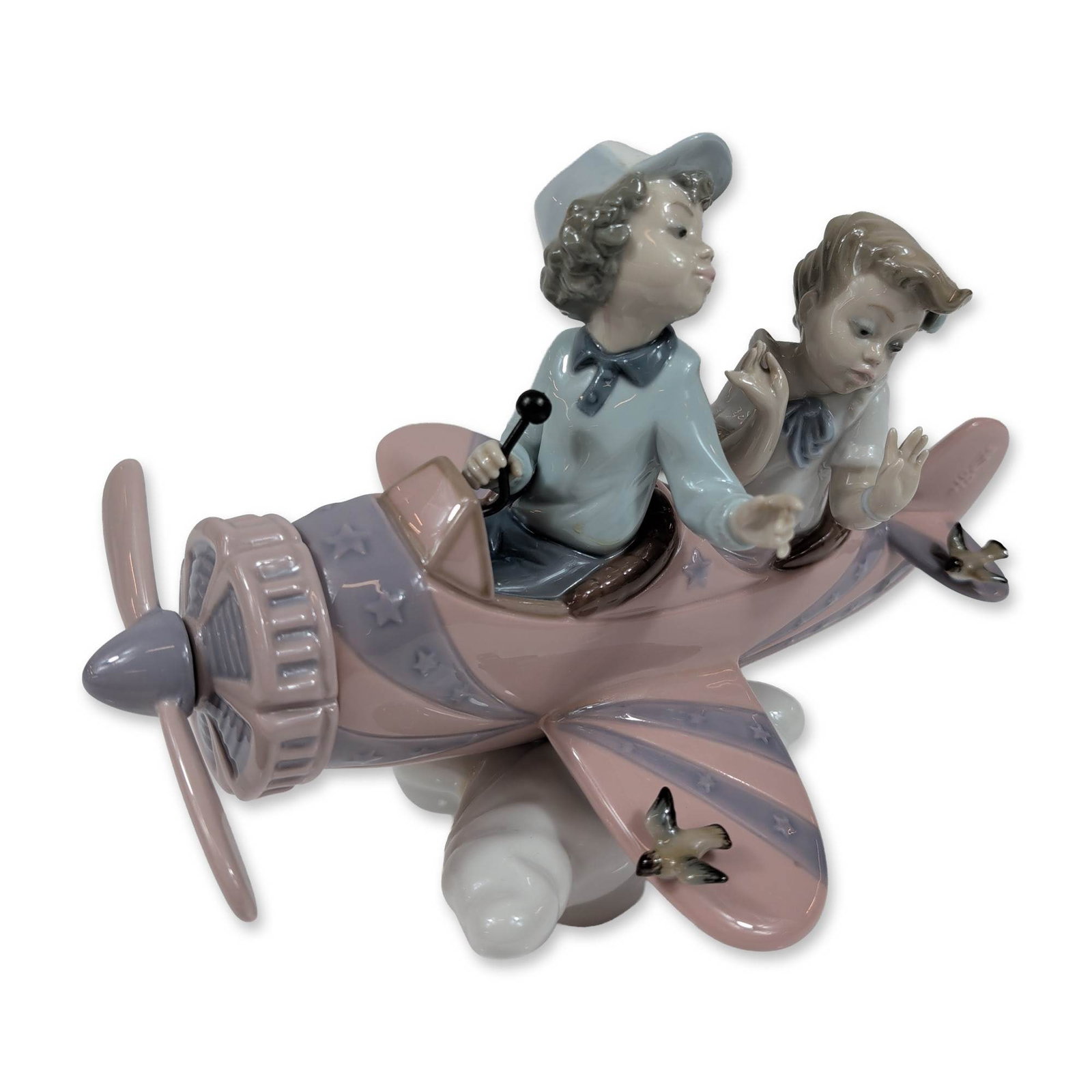 Lladro Don't Look Down Porcelain Figurine: Spanish porcelain by Lladro. Don't Look Down figurine, model 5690, in glazed porcelain. The piece depicts a boy and girl in a vintage-style biplane over a stylized cloud base. The aircraft is finished