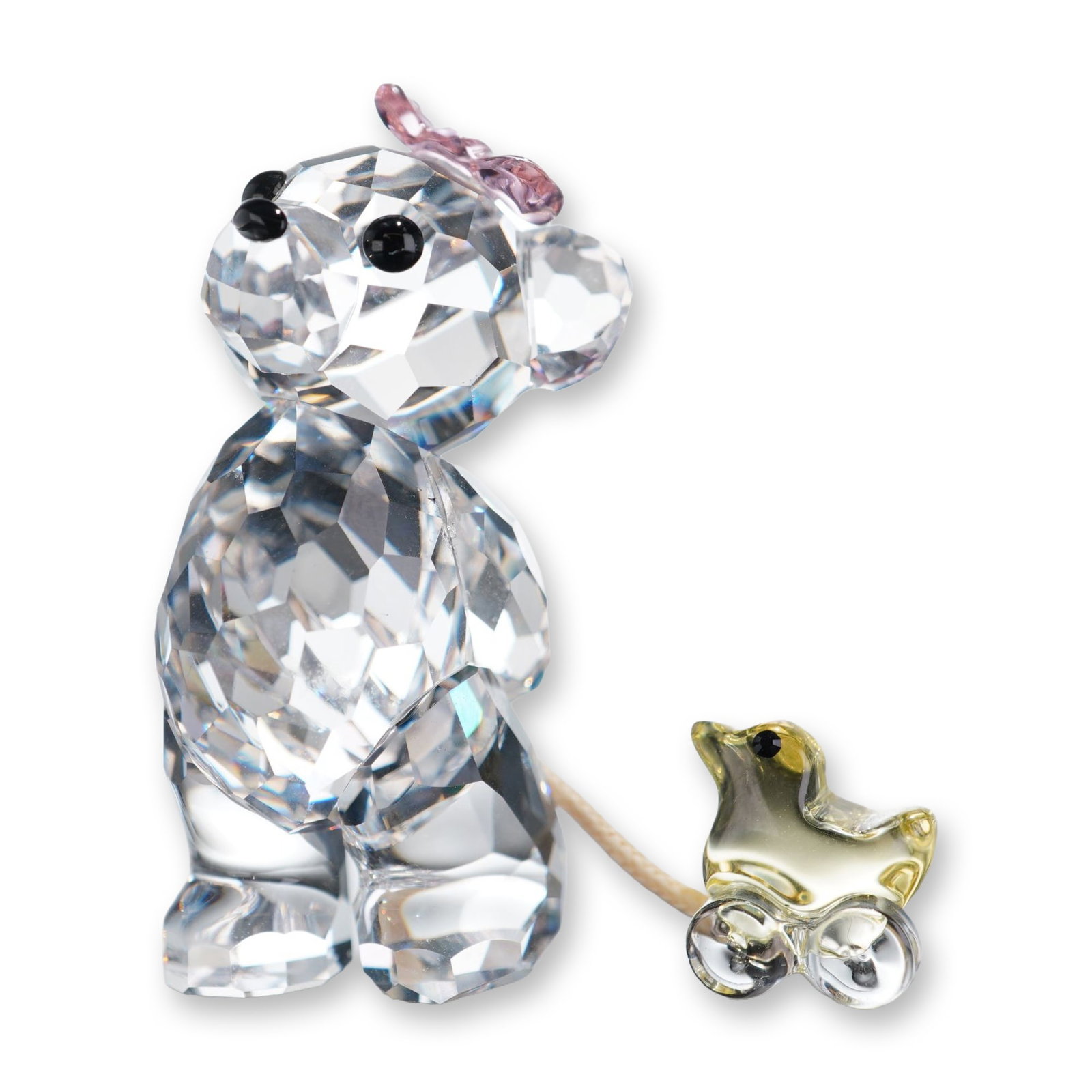 Swarovski Crystal Figurine, Kris Bear - It's a Girl: Swarovski Kris Bear It's a girl figurine in fully faceted clear and colored lead crystal. The bear features black crystal eyes and a small pink crystal bow on its head. The figure is posed holding a b
