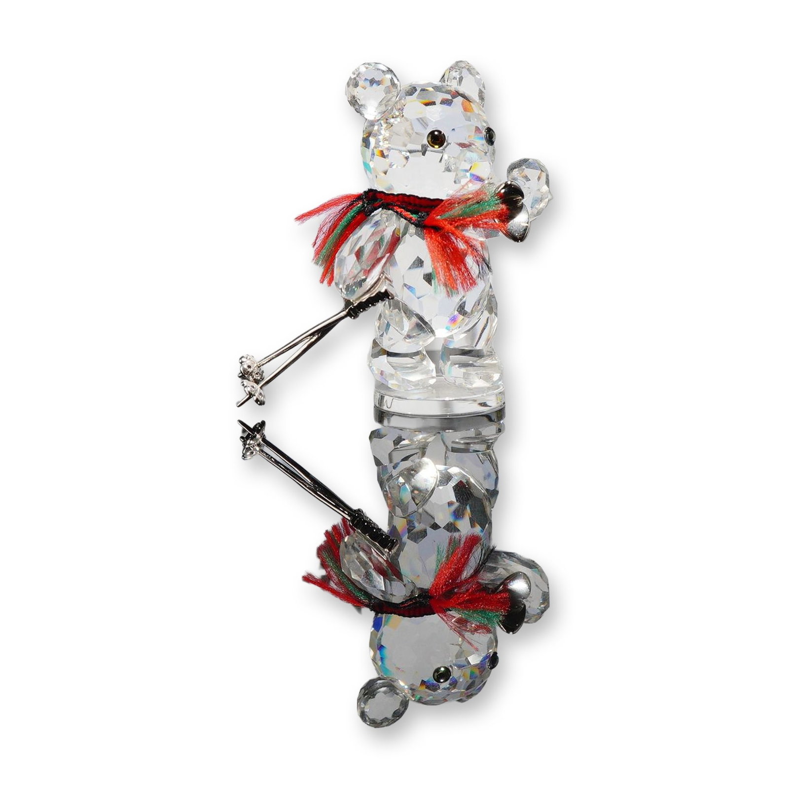 Swarovski Crystal Figurine, Kris Bear with Skis: Kris Bear figurine in faceted clear lead crystal, depicting a bear holding a pair of silver-tone metal skis and two matching poles. The figure is accented with inset black crystal eyes and a red and g