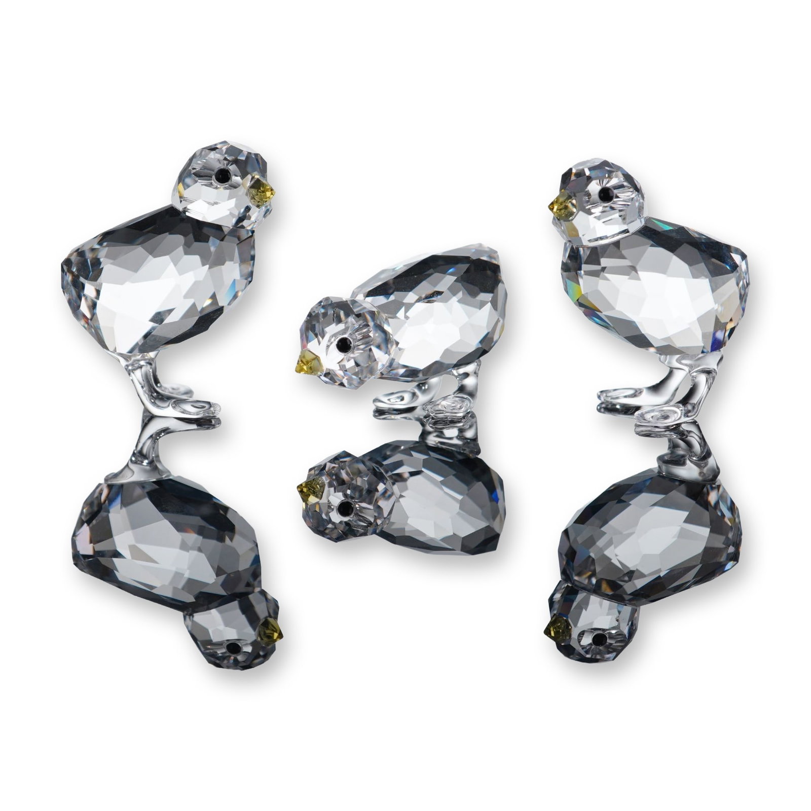 Swarovski Crystal Figurines, Set of 3 Baby Chickens: The trio features two chicks standing upright and one in a pecking pose. Each figurine is constructed with a faceted clear crystal body, black crystal eyes, and a pointed yellow crystal beak. Marked w