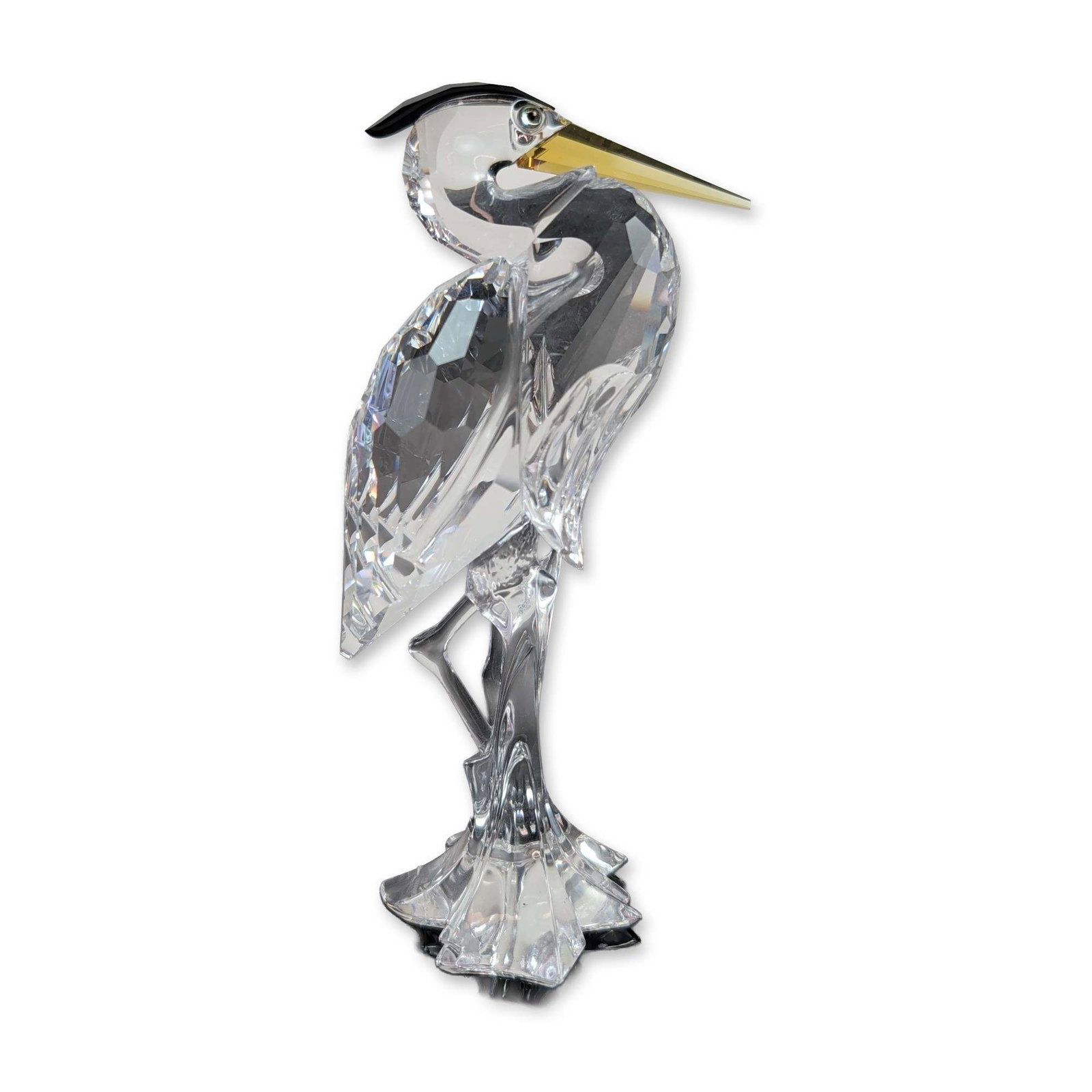 Swarovski Crystal Silver Heron Figurine: Swarovski, Austria. Heron figurine in faceted clear crystal, featuring the Silver Heron pattern with a black crystal crest and yellow-toned crystal beak mounted on an abstract faceted base. The unders