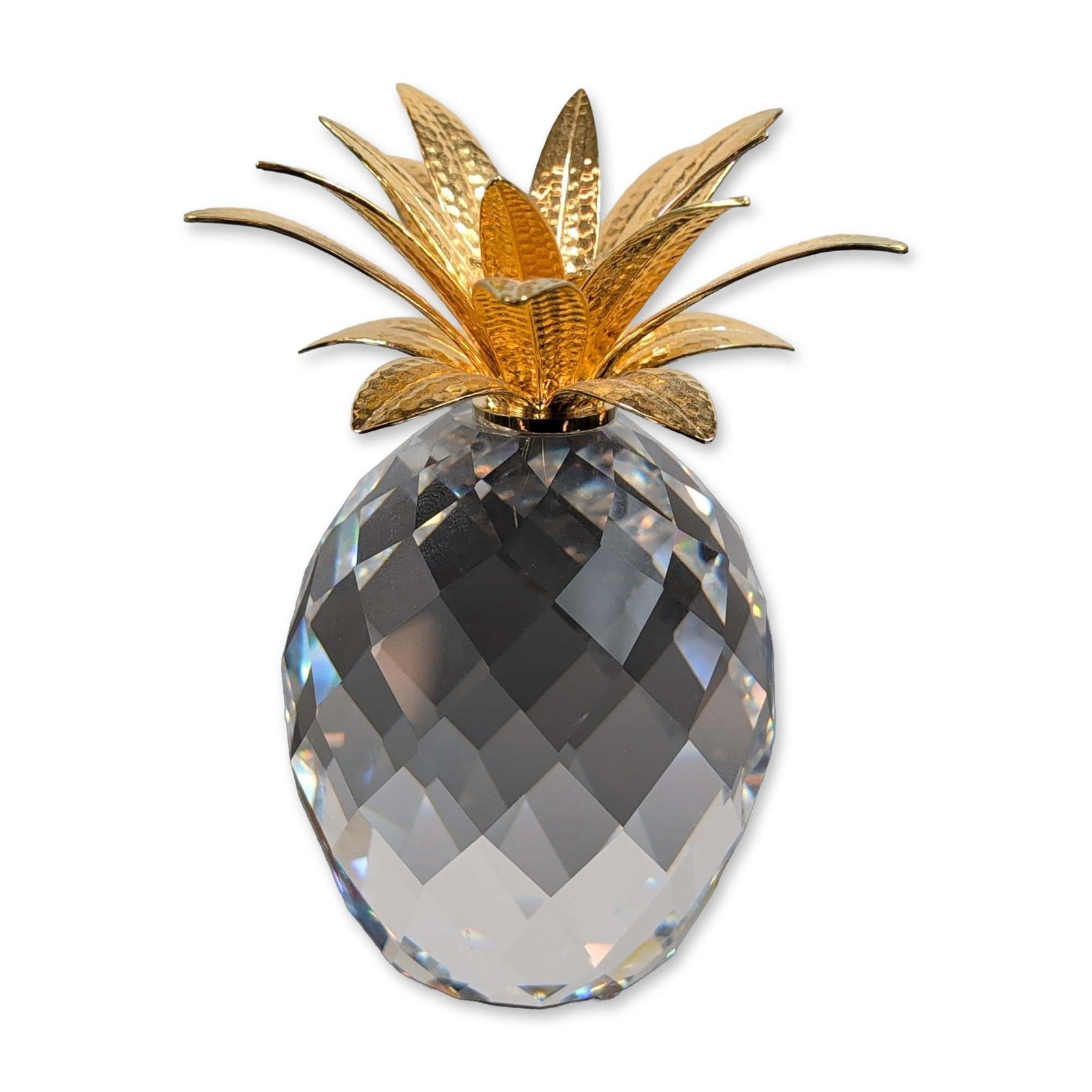 Swarovski Crystal Figurine, Large Gold Pineapple (Hammered Leaves): Stylized pineapple figurine in faceted clear lead crystal with gold-plated metal accents. The piece is constructed with an egg-shaped body featuring multi-faceted clear lead crystal designed for light