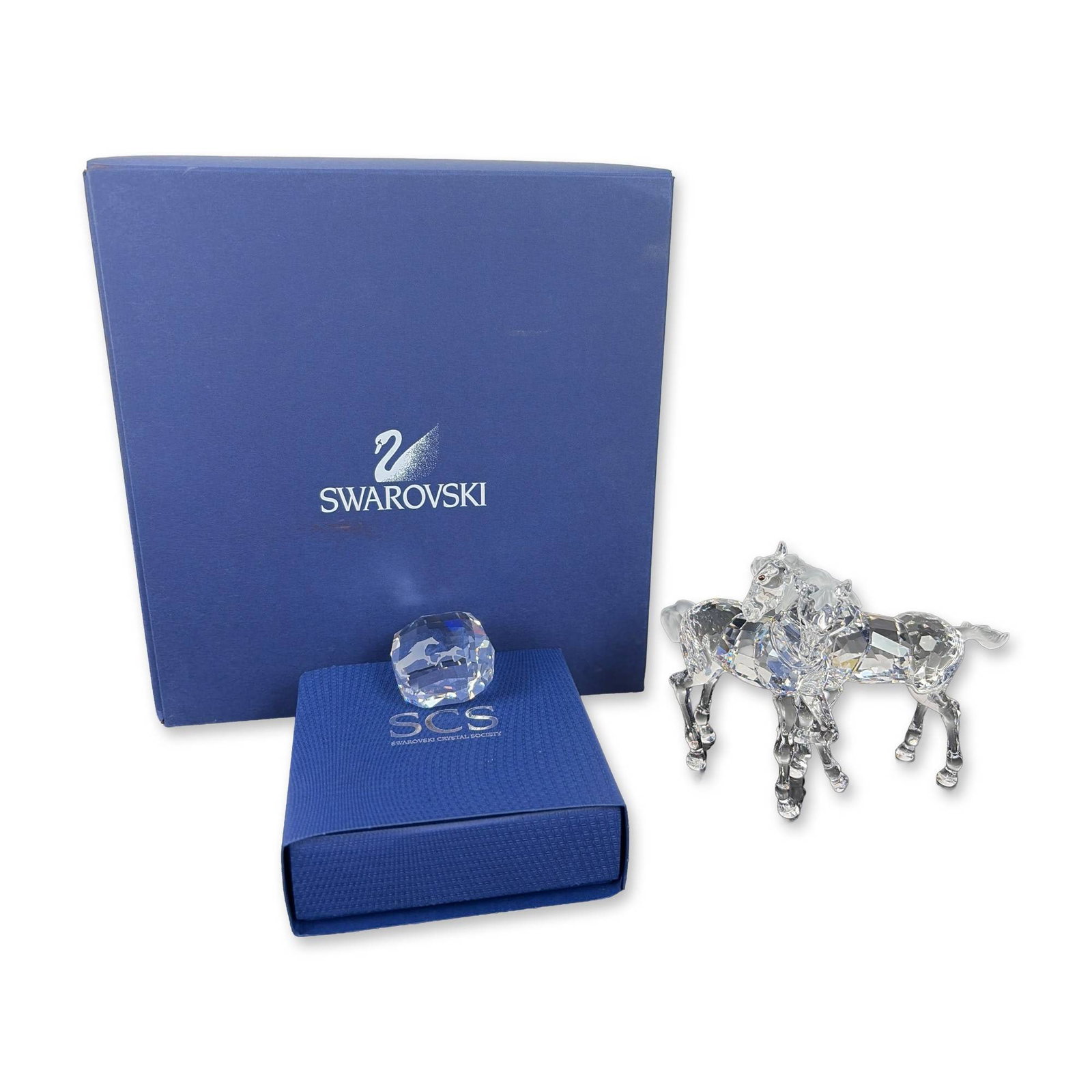 2pc Swarovski Crystal Foals Figurine and Horses Paperweight: Two-piece lot featuring Swarovski a faceted and frosted lead crystal Foals figurine that depicts two intertwined foals and is etched with designer Martin Zendron's signature and dated 2005. The accomp