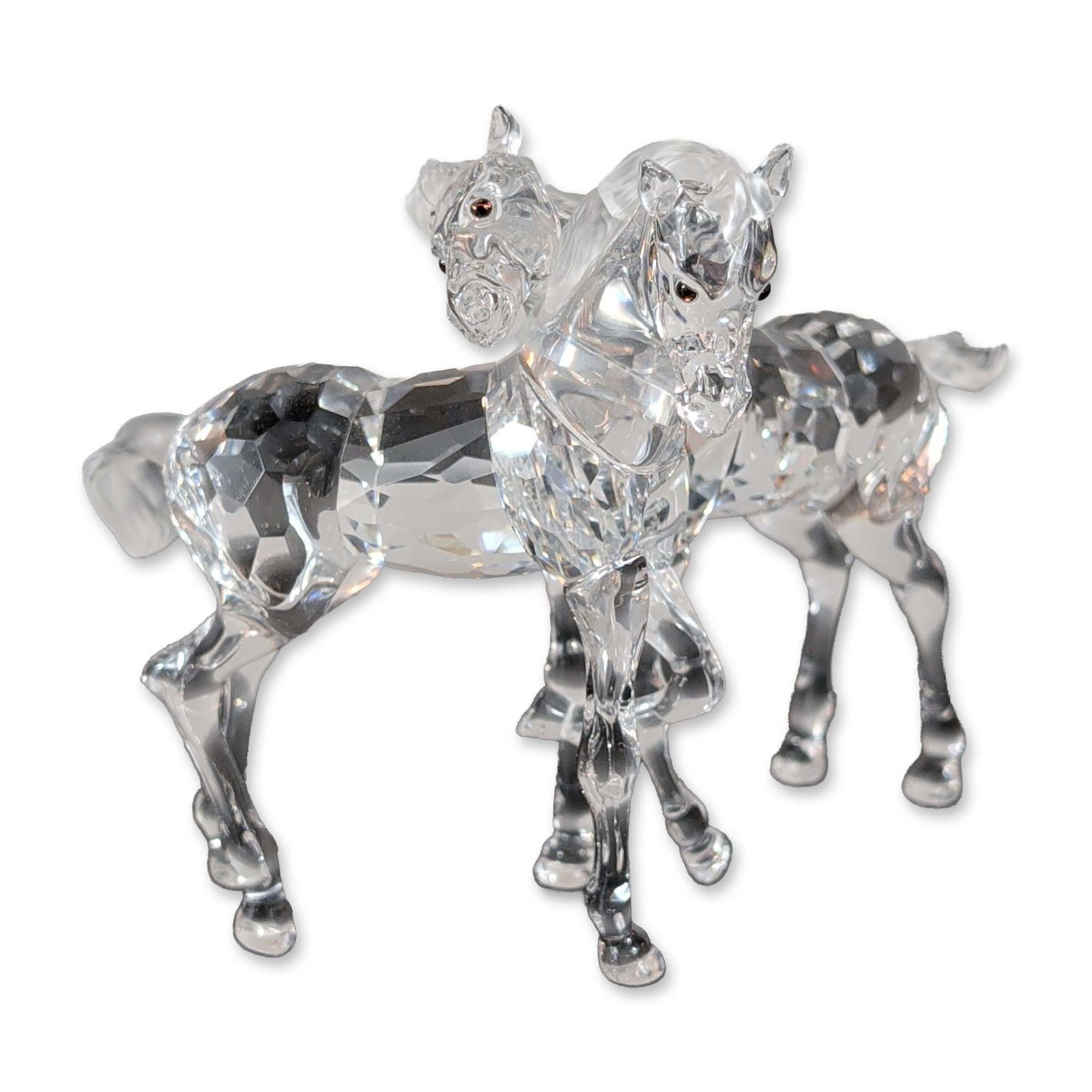 Swarovski Crystal Figurine, Foals Playing: Swarovski, pair of foals in clear faceted crystal. The figurine is depicted in active poses with frosted or matte finished manes and tails. Small dark inset stones or beads are used for the eyes. A sm