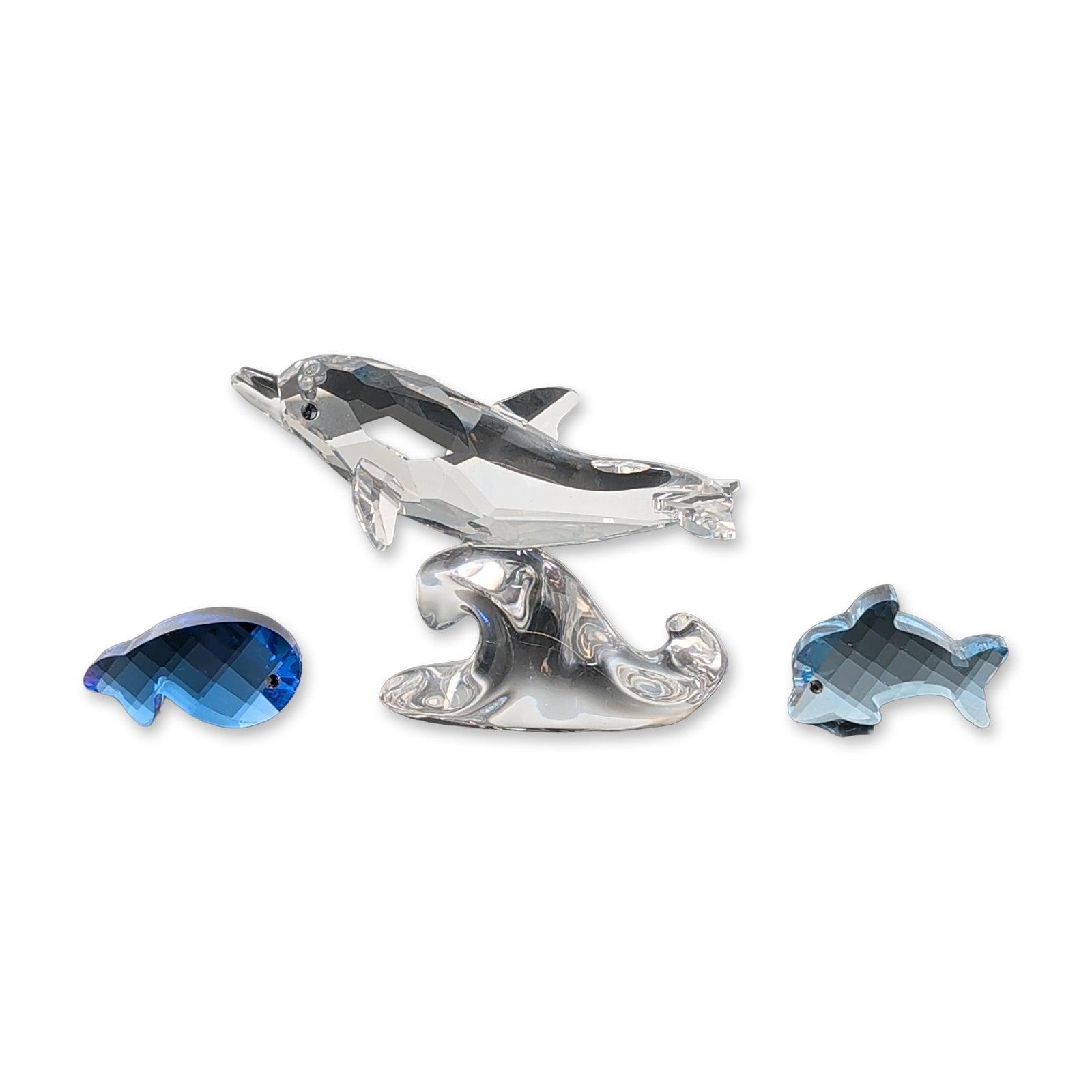 3pc Swarovski Crystal Marine Animal Figurine Collection: Collection of Swarovski lead crystal figurines featuring marine animals. The group includes a faceted clear crystal dolphin mounted on a base modeled as a wave, a small faceted light blue baby dolphin