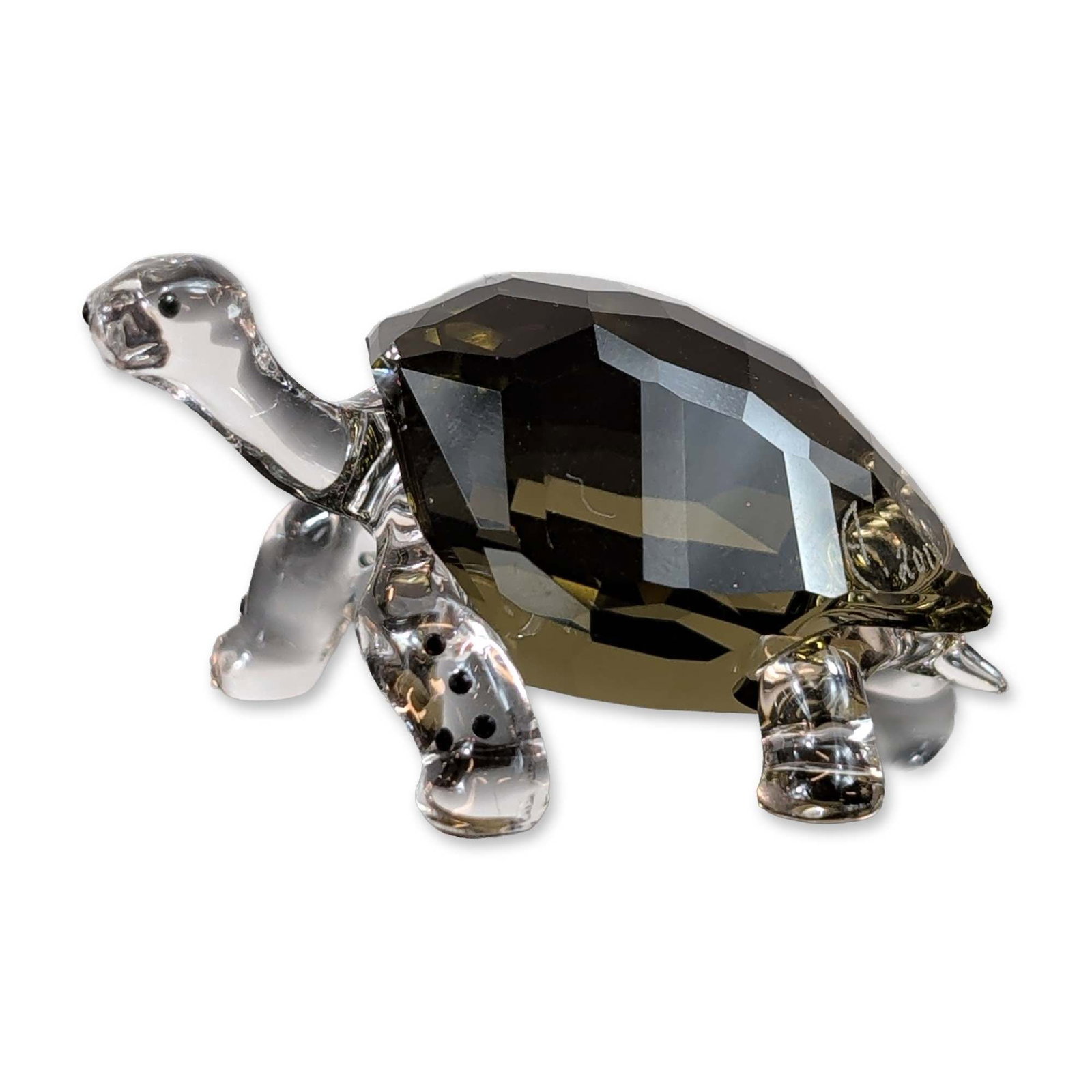 Swarovski Crystal 2010 Event Figurine, Galapagos Tortoise, Signed: Figurine in faceted crystal and smooth glass, featuring a smoky-topaz or olive-brown faceted carapace with clear glass limbs, head, and tail. The head includes small black pigment applications for the