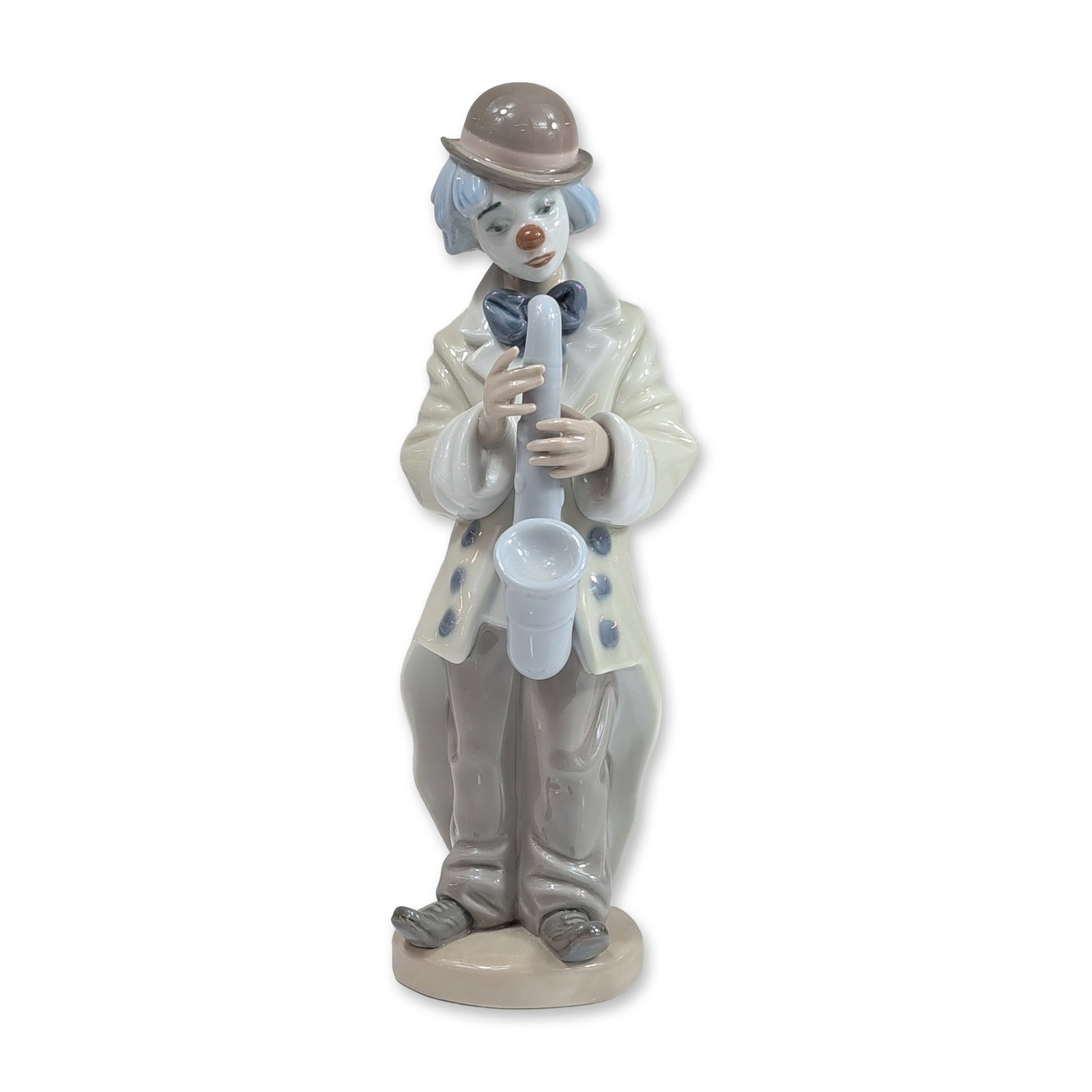 Lladro Porcelain Figurine, Sad Sax 1005471: Lladro (Spanish, 20th century). Glazed porcelain figurine titled Sad Sax, model number 5471, depicting a melancholic clown playing a saxophone. The figure is rendered in a cream-colored coat with blue