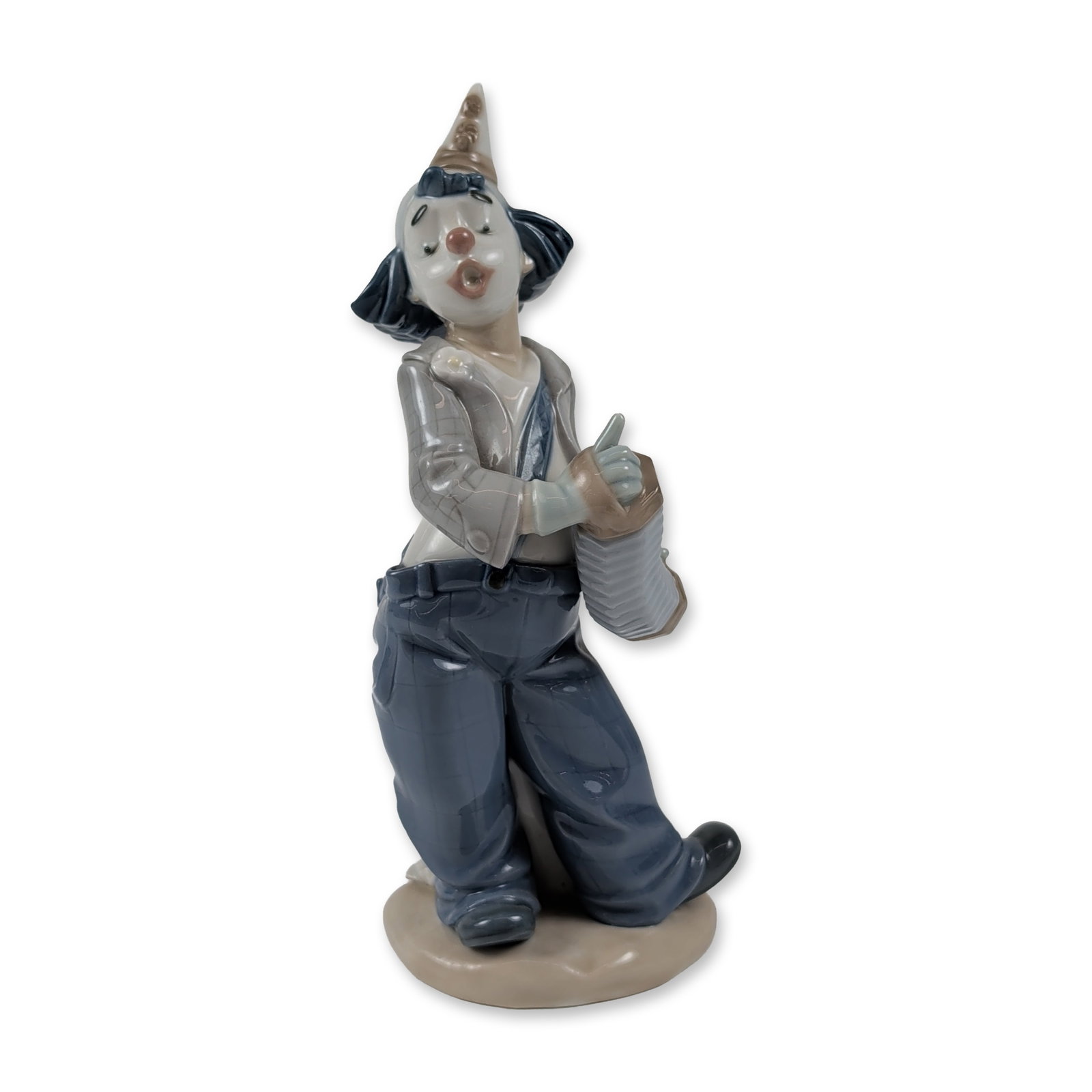 Nao by Lladro Porcelain Clown Figurine, Concertina: Lladro (Spain) glazed porcelain figurine featuring a standing figure singing, dressed in classic clown makeup, a gray plaid jacket over a white shirt, blue trousers, and a small conical hat, while pla