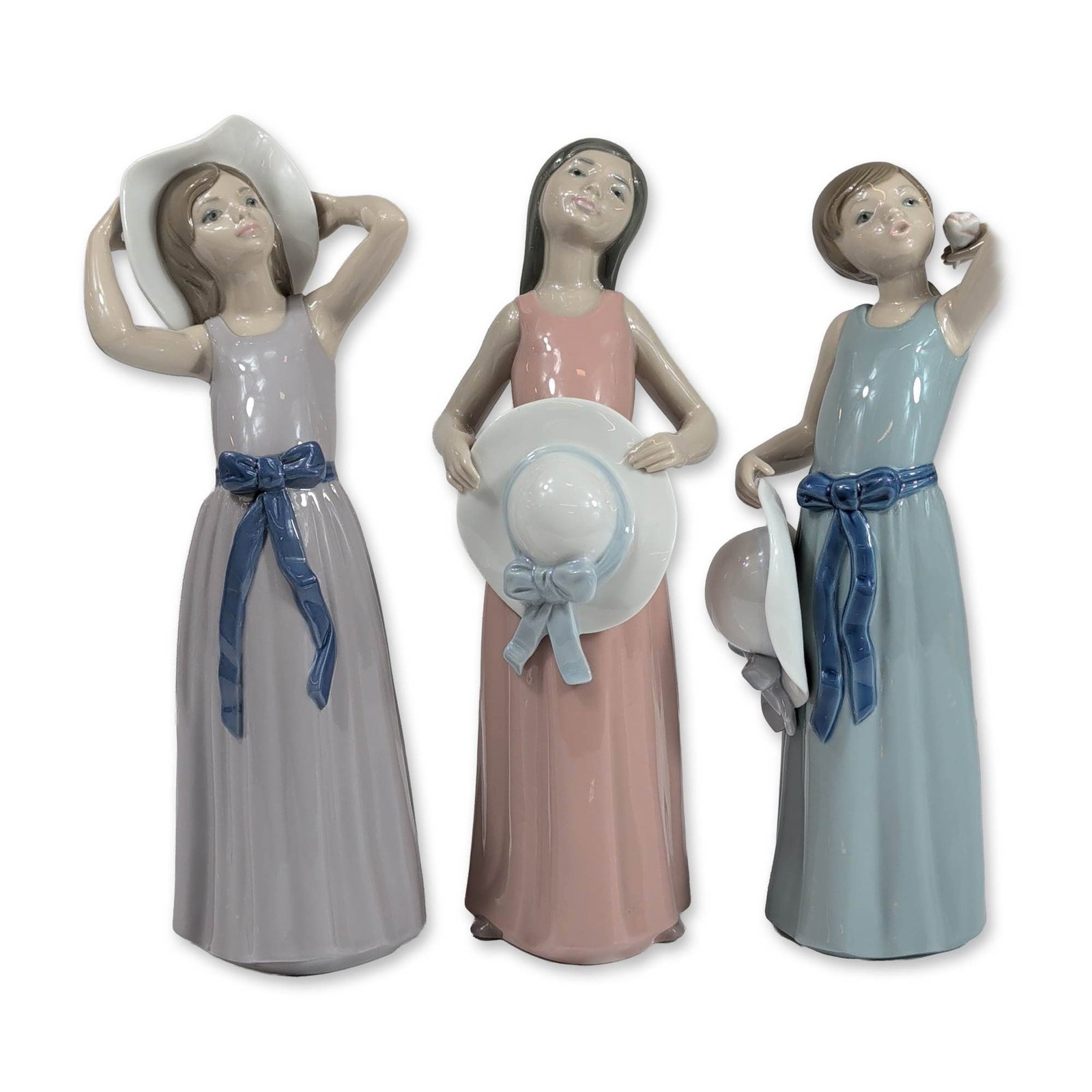3pc Lladro Spanish Porcelain Figurines: Lladro. Trio of glazed porcelain figurines, each depicting a young woman in a summer dress with a sun hat. The collection includes: 5010 Coiffure-Girl wistraw hat, 5008 Static-Girl Wistraw Hat and 501