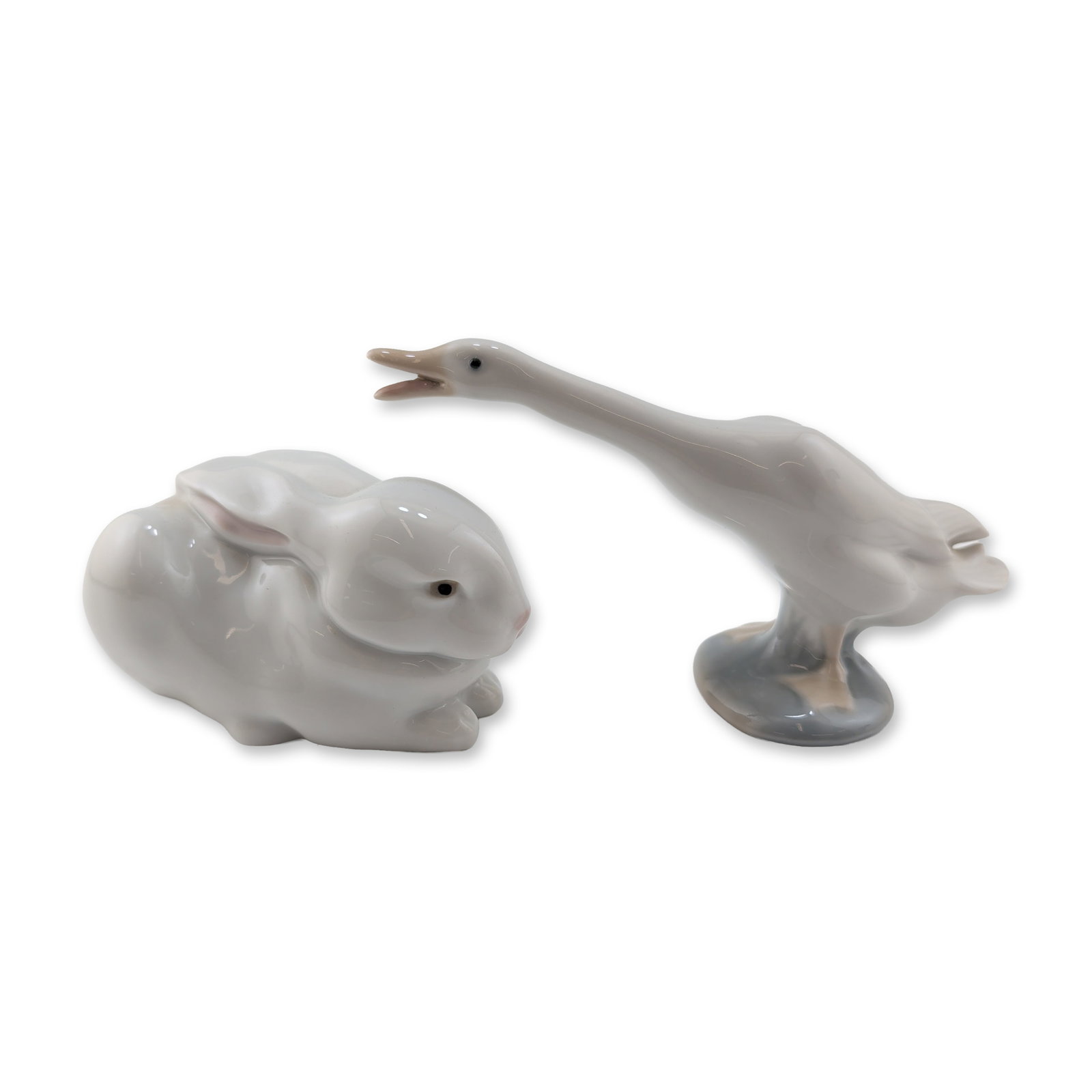Two Lladro Glazed Porcelain Animal Figurines: Lladro, Spain. Two glazed porcelain figurines including a single duck with its neck extended and a rabbit. Both pieces feature a high-gloss finish and the characteristic muted tonal palette associated