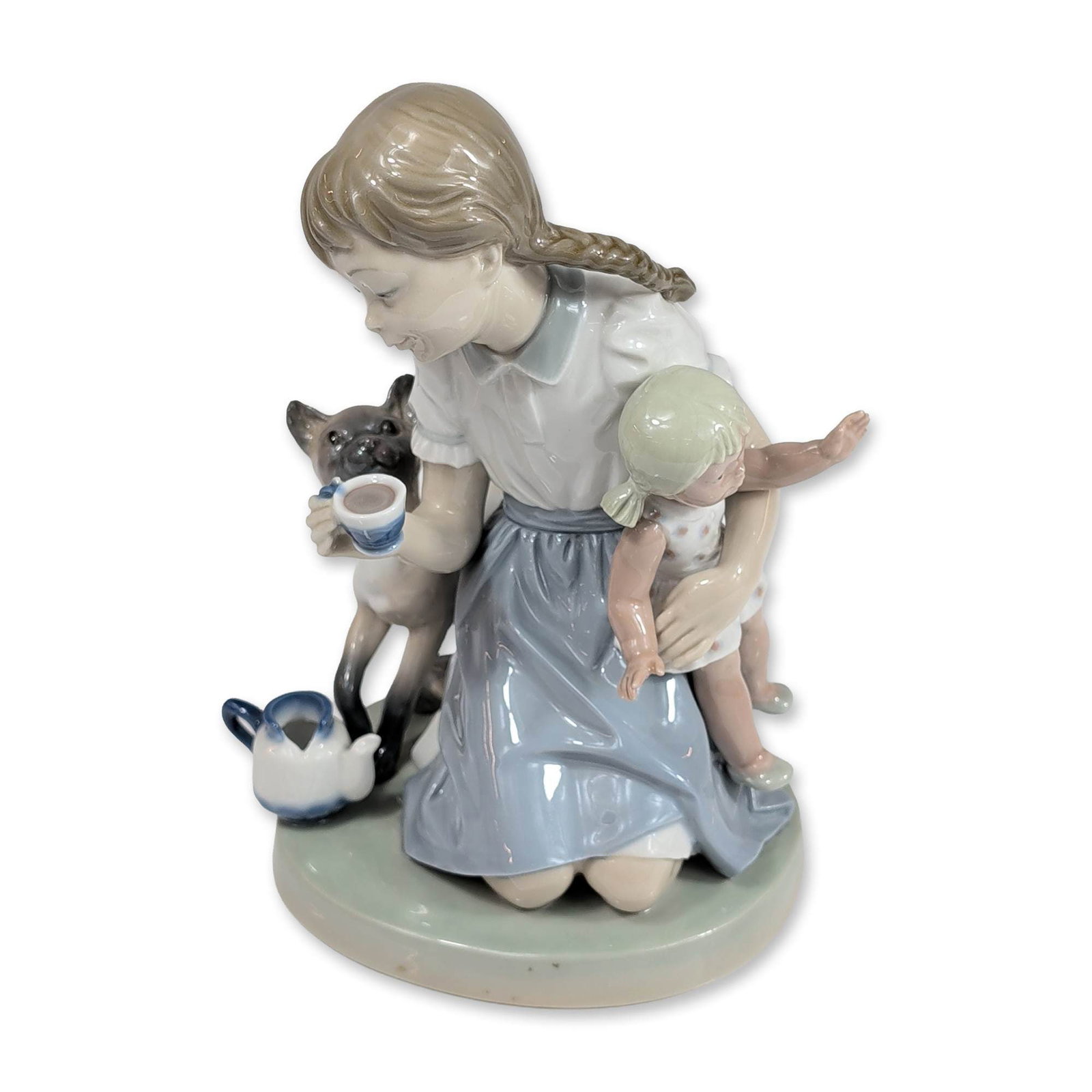 Lladro Porcelain Figurine, Childs Play 1001280: Lladro Spanish glazed porcelain figurine, model number 1280 titled Childs Play. The piece depicts a domestic scene of a young girl with a single long braid seated with a baby in her lap. A Siamese cat